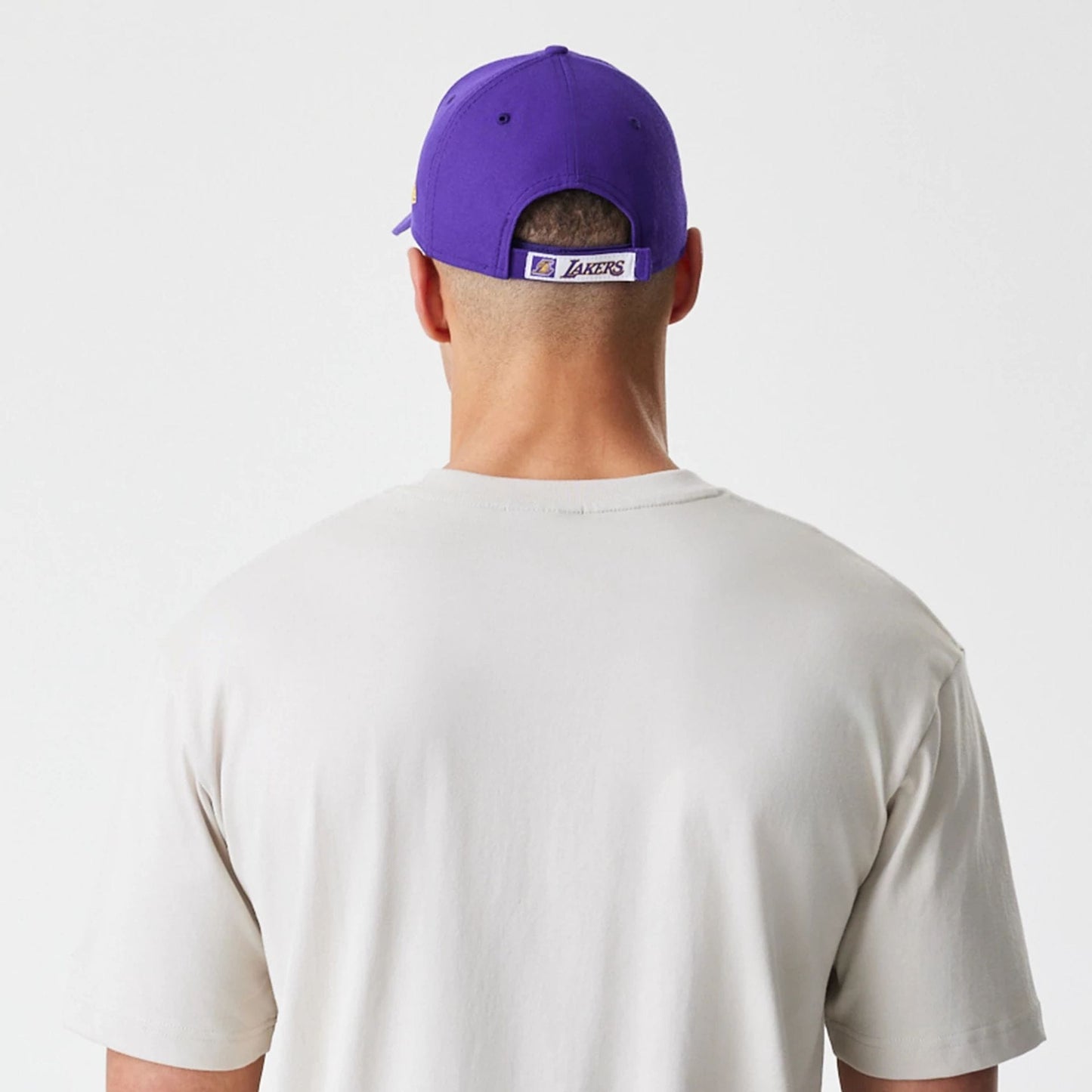 The Male model is wearing LA Lakers Modern Driver Light Beige T-Shirt 5