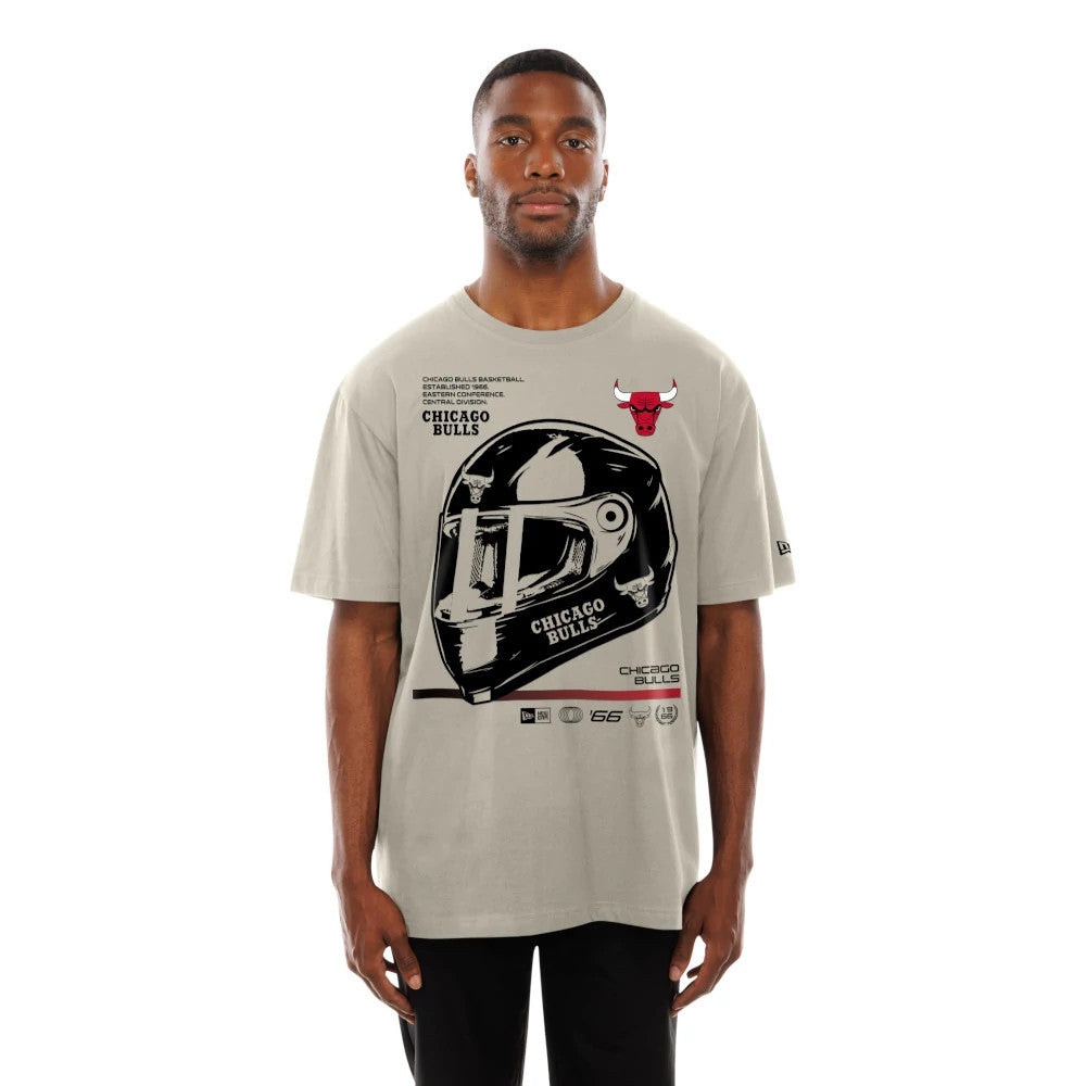 New Era Chicago Bulls Modern Driver Light Beige T-Shirt, front view featuring a large black and white graphic of a racing helmet with the Chicago Bulls name, a red bull logo on the left chest, and a small black New Era logo on the left sleeve.