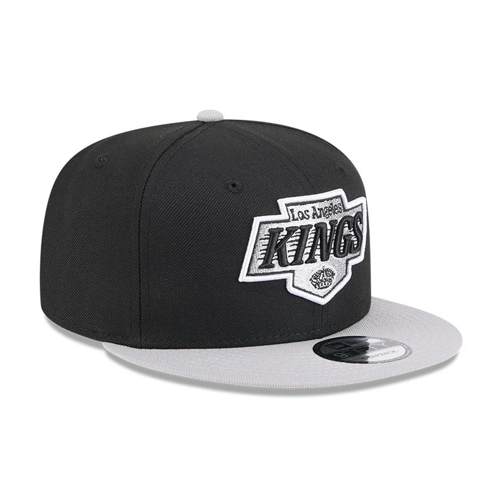 LA Kings NHL Evergreen Black New Era 9FIFTY Snapback Adjustable Cap, front view showing the black and white embroidered Kings logo on the front panel above a grey visor with a 9FIFTY size sticker.