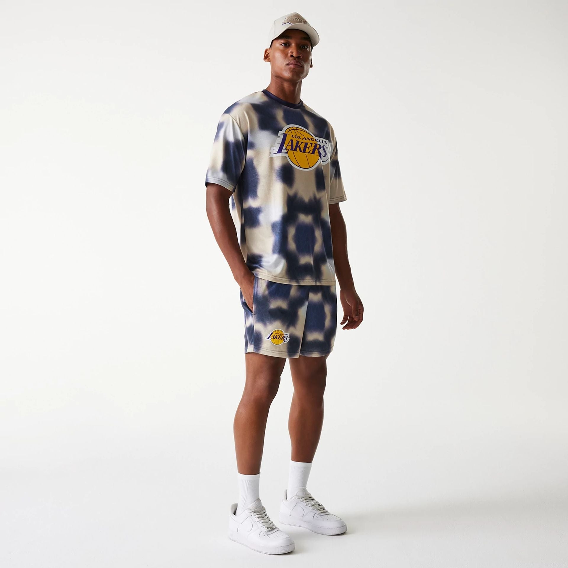 The Male model is wearing LA Lakers NBA All Over Print Cream Shorts 8
