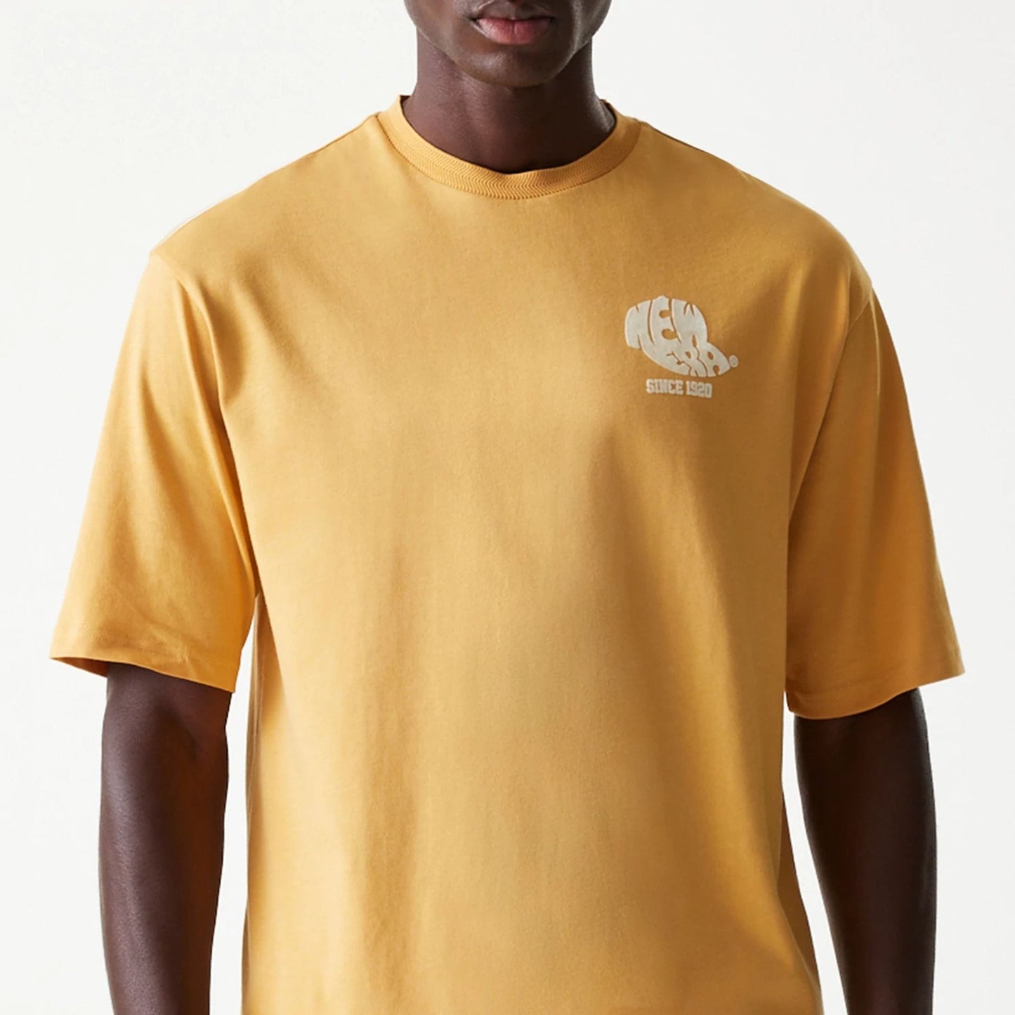 The Male model is wearing New Era Graphic Beige Oversized T-Shirt 3