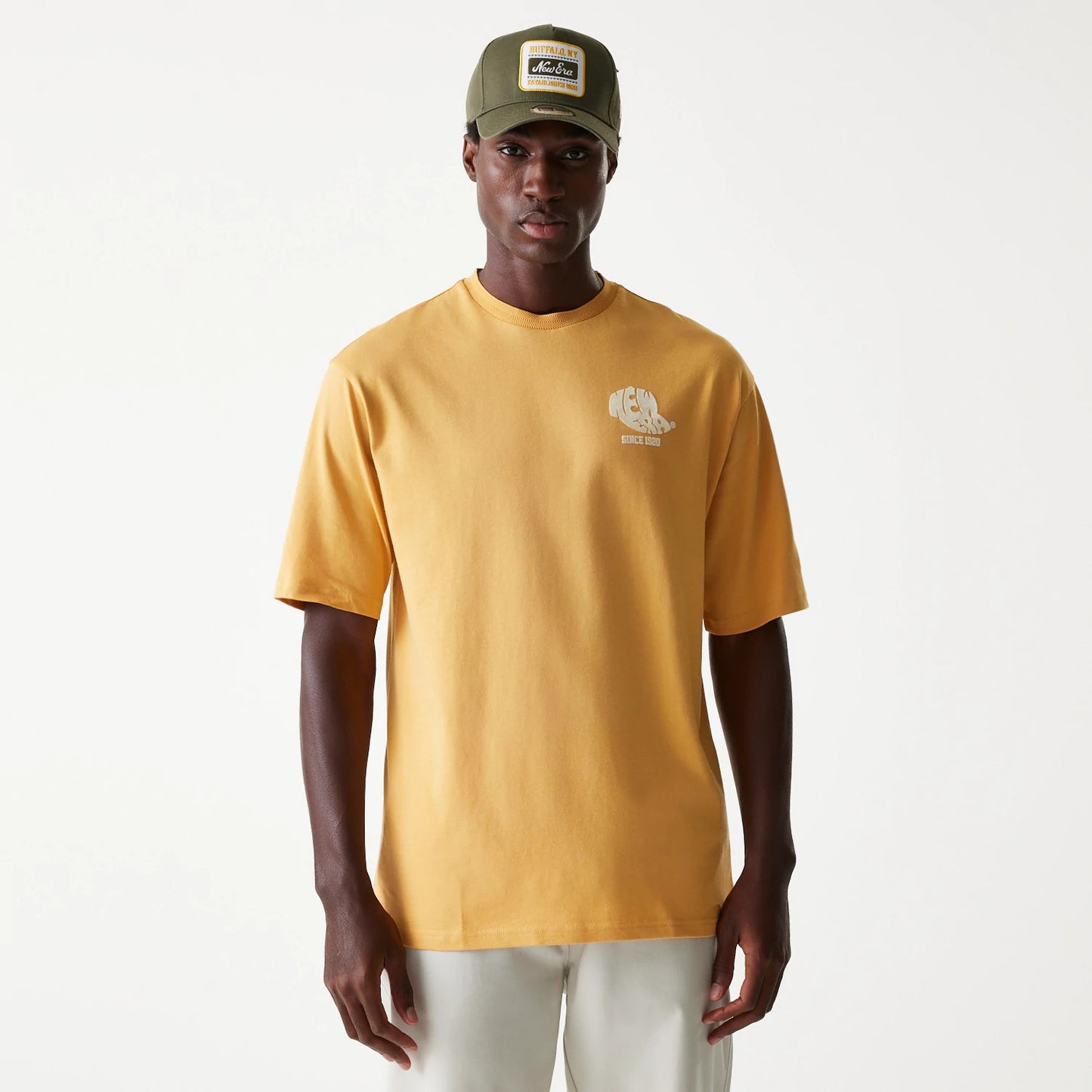 The Male model is wearing New Era Graphic Beige Oversized T-Shirt 1