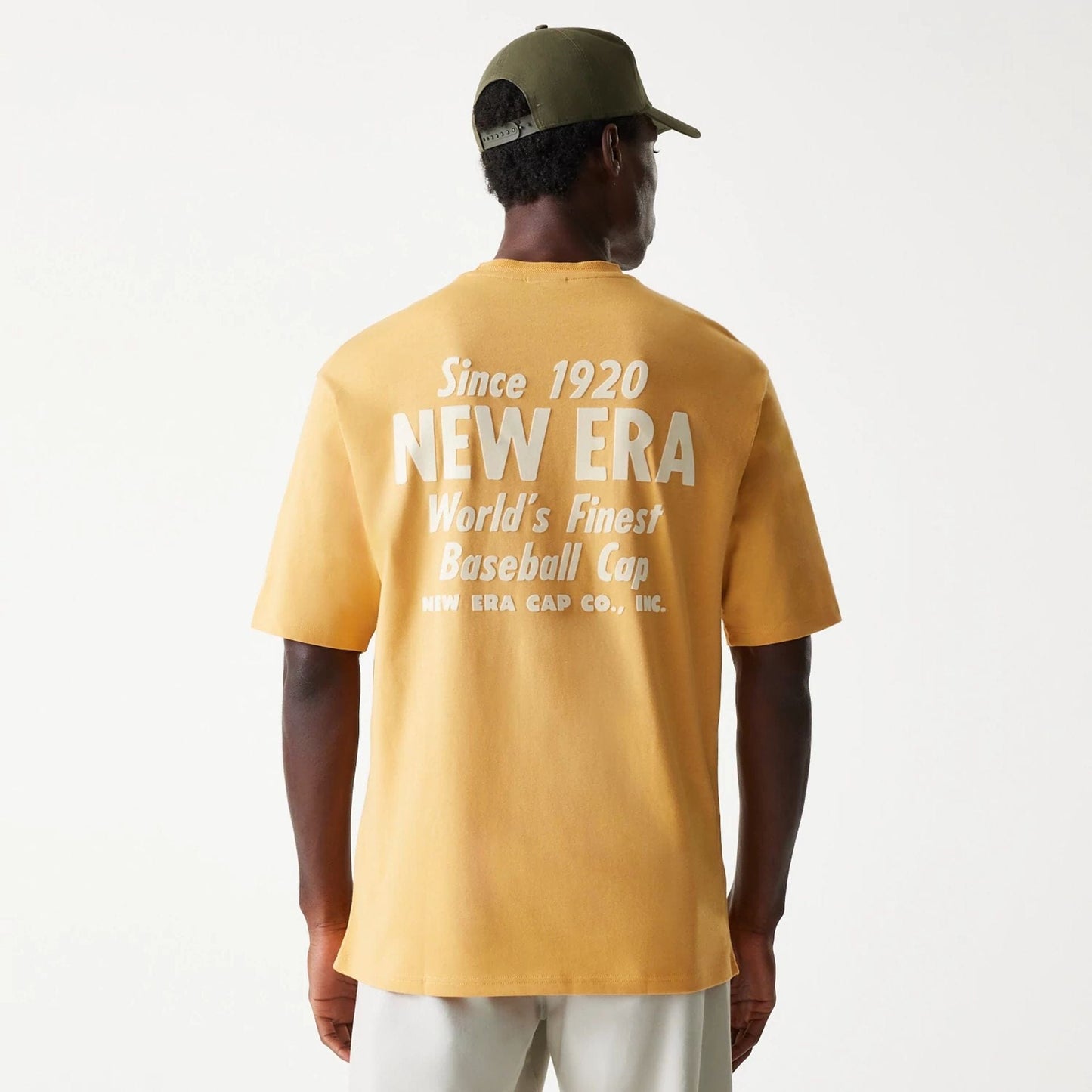 The Male model is wearing New Era Graphic Beige Oversized T-Shirt 2