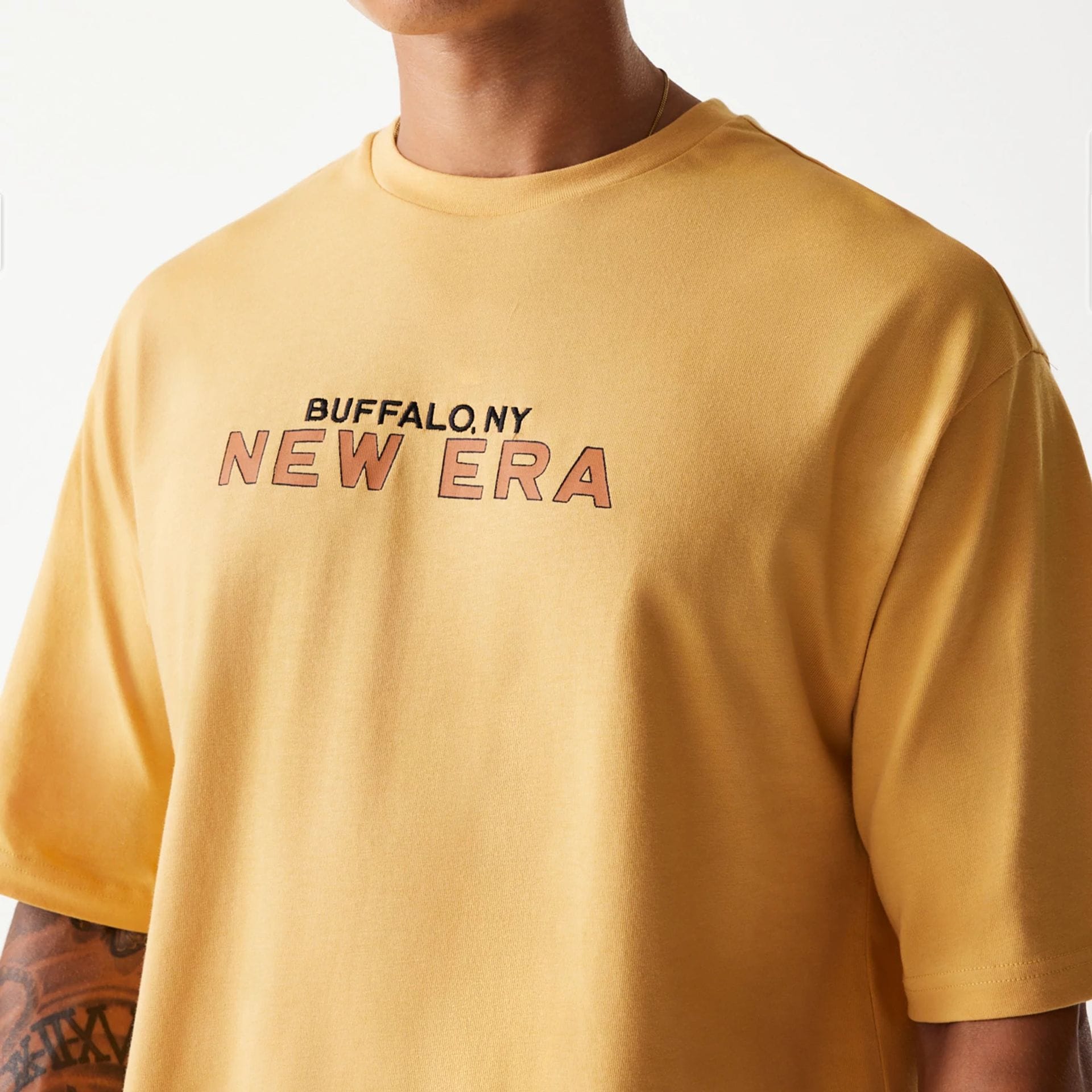 The Male model is wearing New Era Vacation Graphic Beige Oversized T-Shirt 5