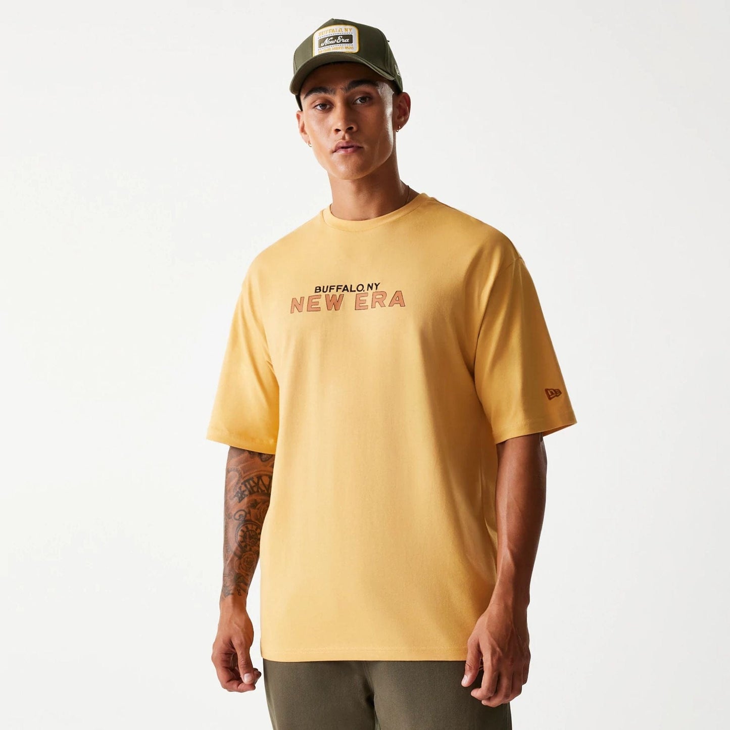 The Male model is wearing New Era Vacation Graphic Beige Oversized T-Shirt 1