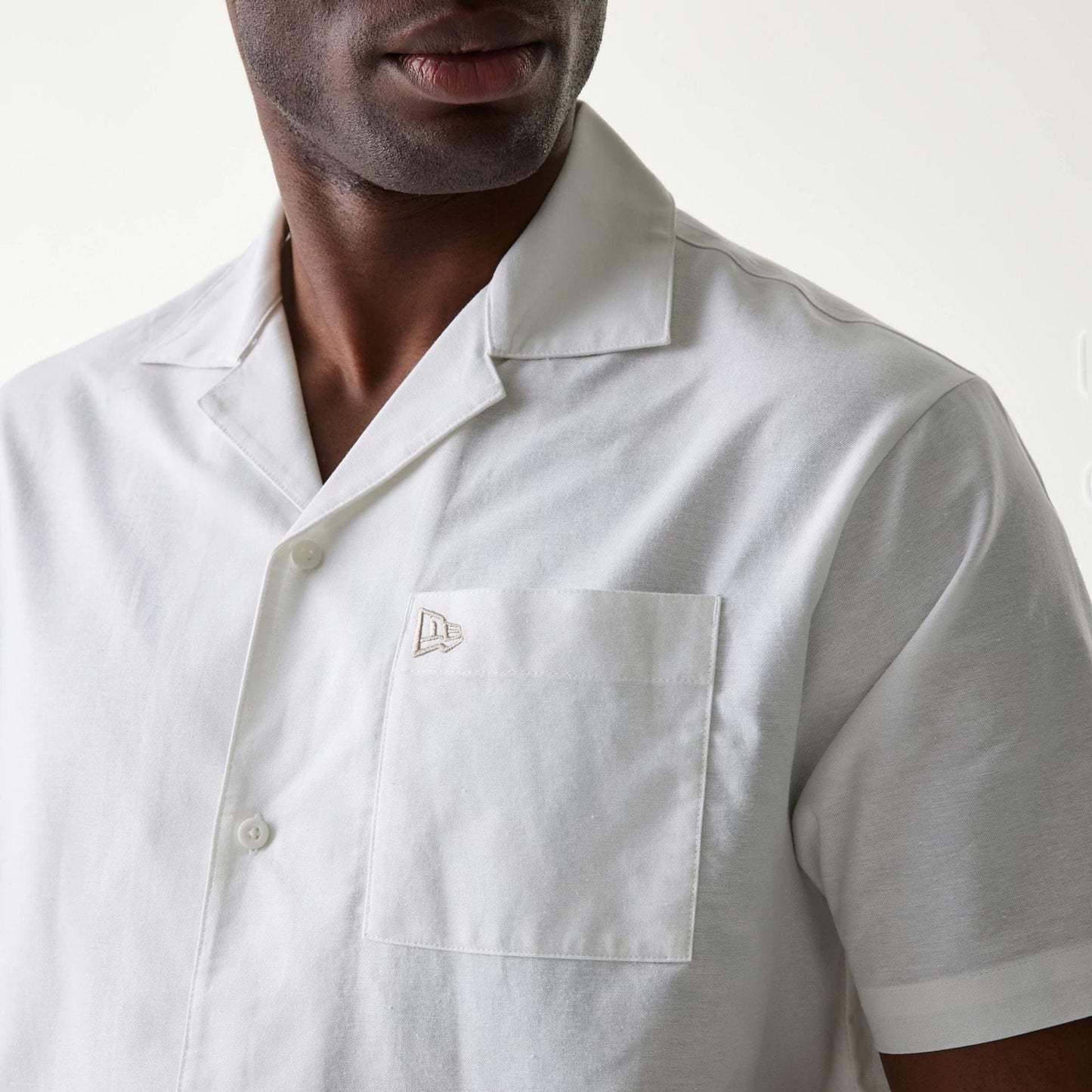 The Male model is wearing New Era White Revere Short Sleeve Shirt 4
