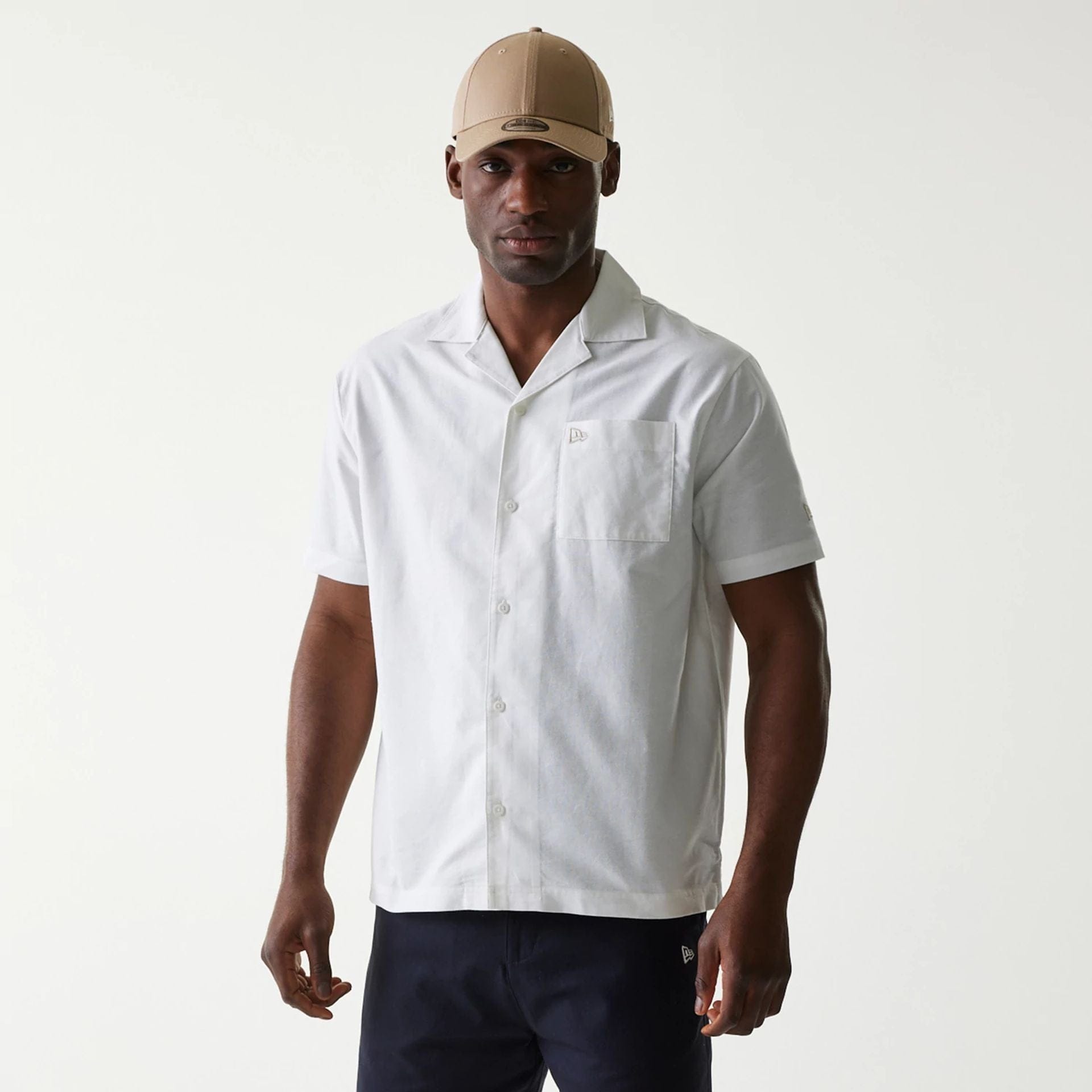 The Male model is wearing New Era White Revere Short Sleeve Shirt 1