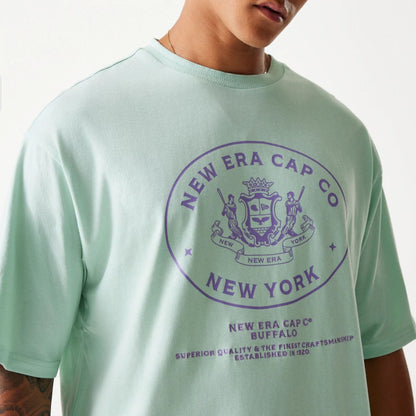 The Male model is wearing New Era Crest Pastel Green Oversized T-Shirt 3