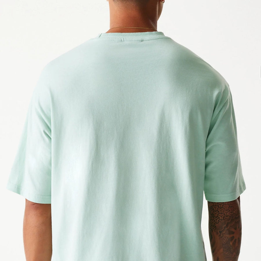 The Male model is wearing New Era Crest Pastel Green Oversized T-Shirt 7