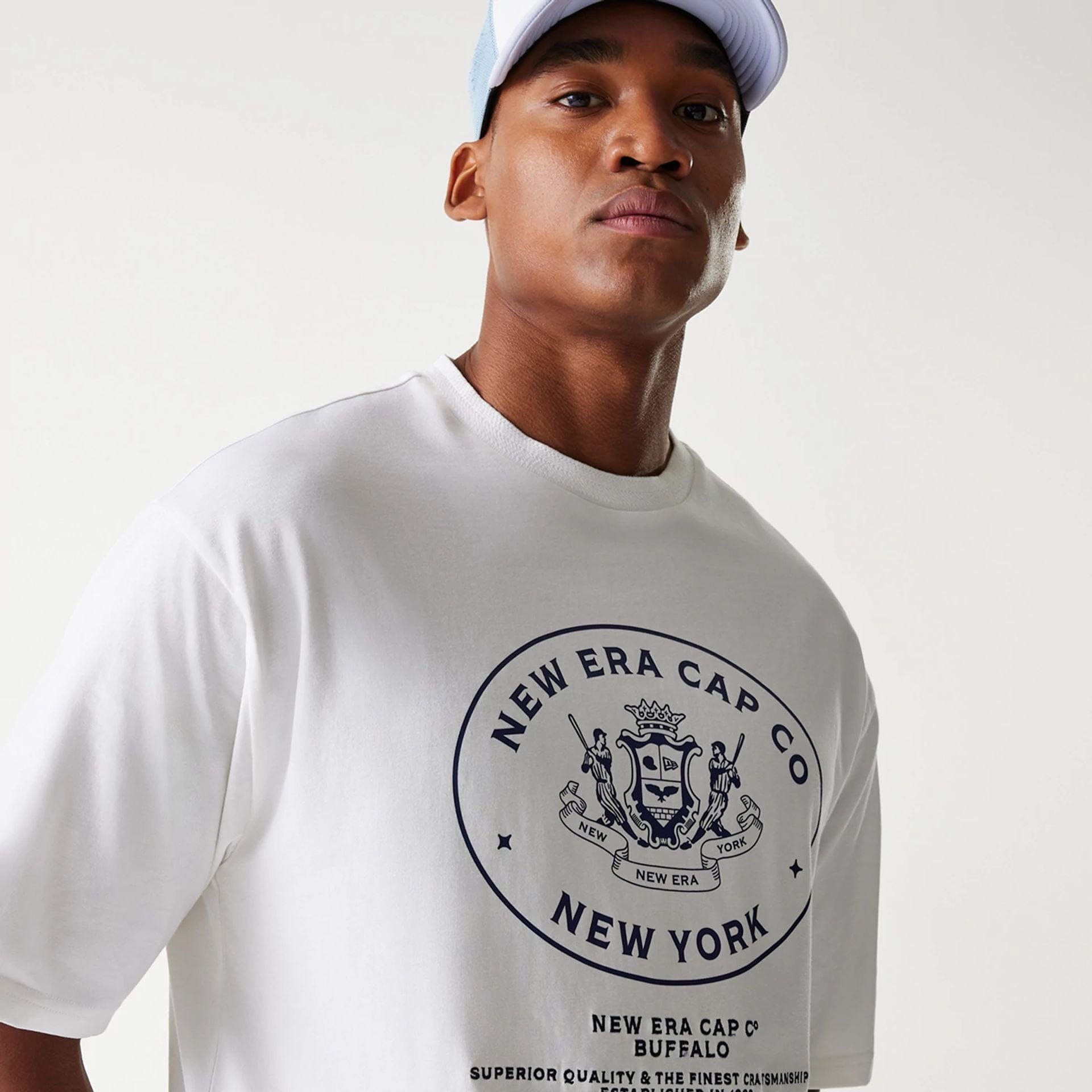 The Male model is wearing New Era Crest White Oversized T-Shirt 4