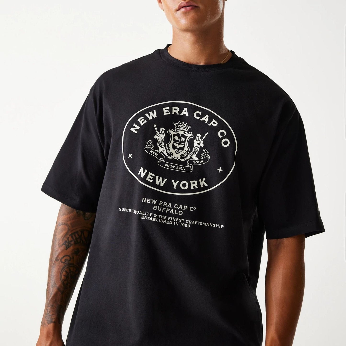 The Male model is wearing New Era Crest Black Oversized T-Shirt 3