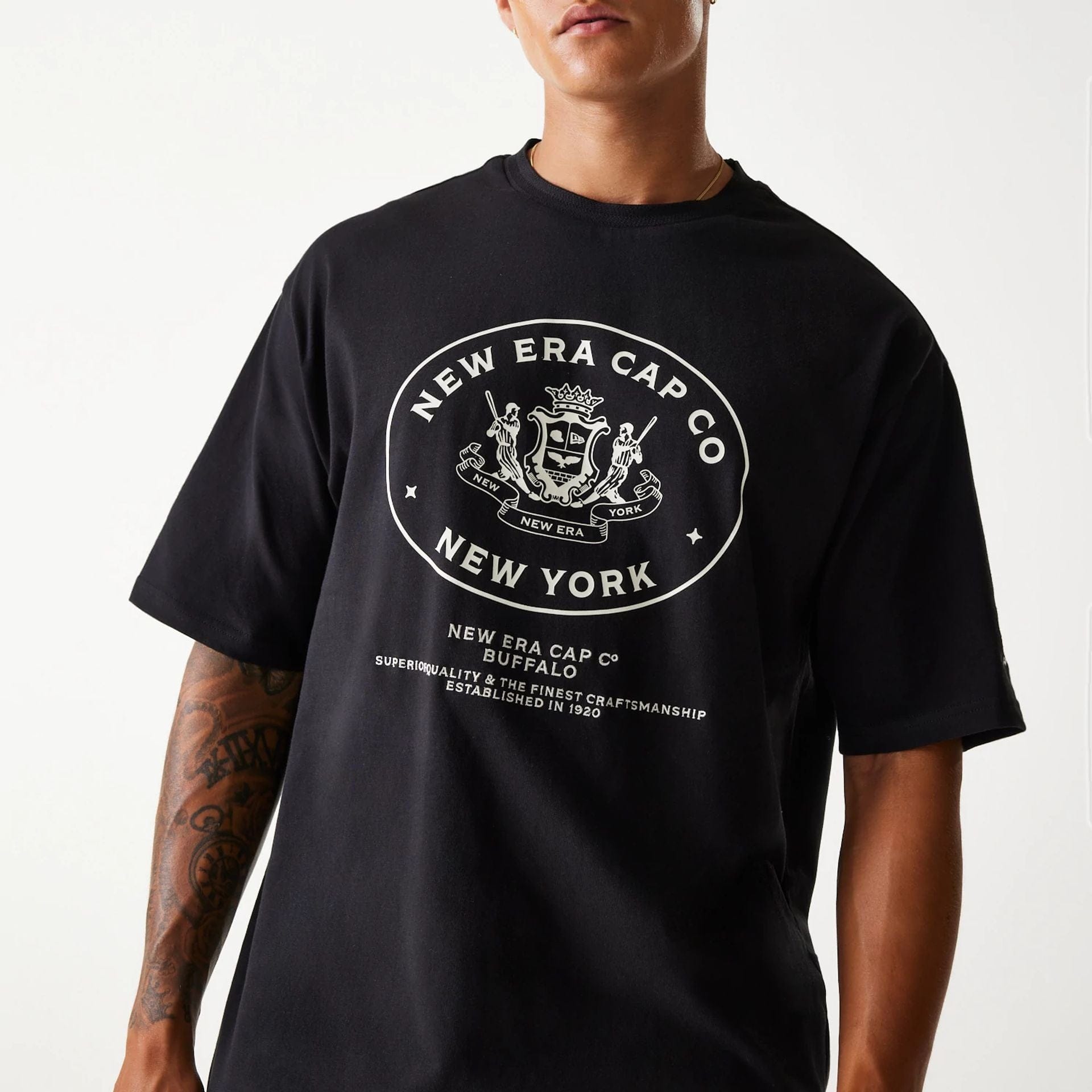 The Male model is wearing New Era Crest Black Oversized T-Shirt 3