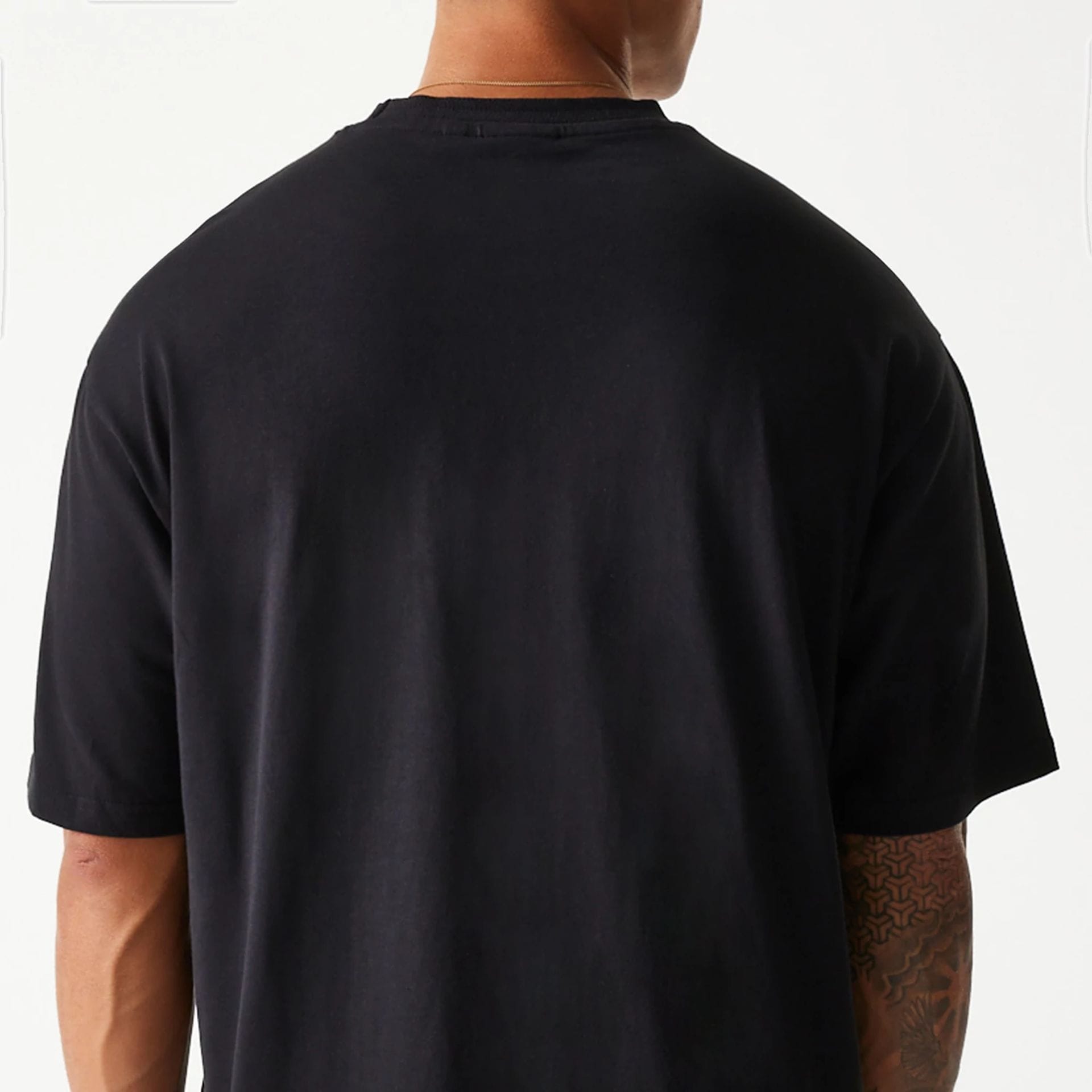 The Male model is wearing New Era Crest Black Oversized T-Shirt 7