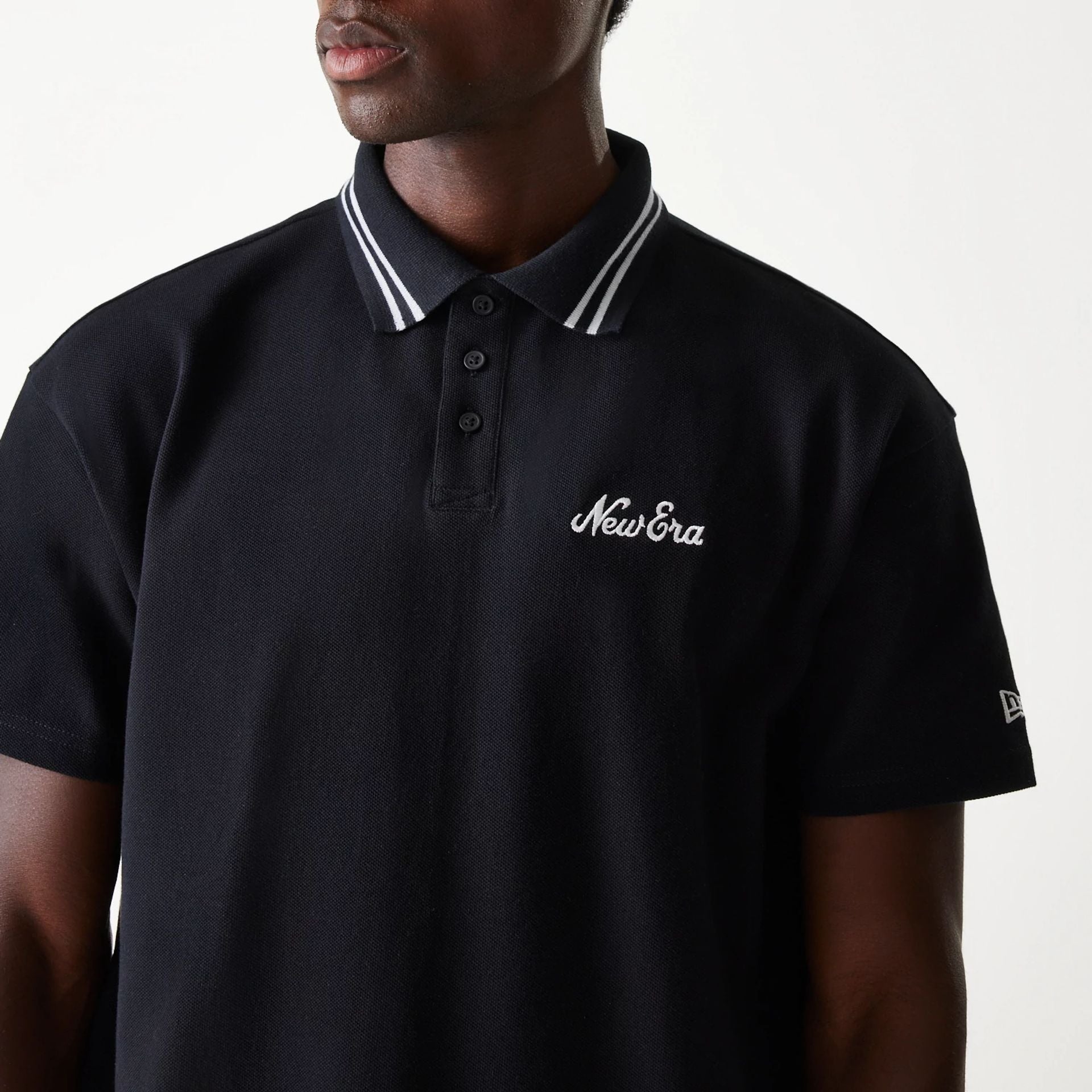 The Male model is wearing New Era Drop Shoulder Black Polo Shirt 3