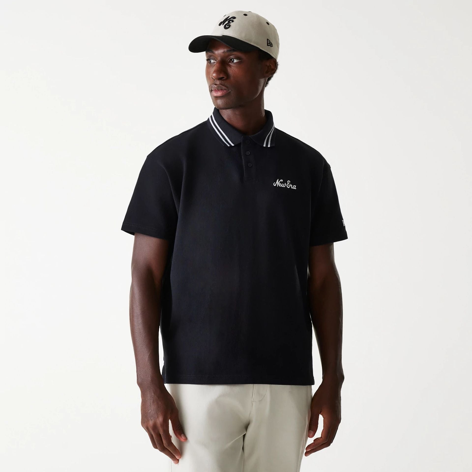 The Male model is wearing New Era Drop Shoulder Black Polo Shirt 1