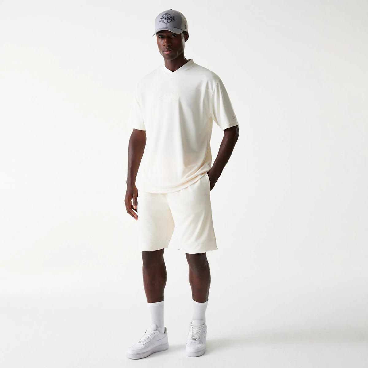 New Era LA Lakers NBA Tonal Open White Mesh Shorts, on-model view showing the relaxed fit white shorts paired with a coordinating white T-shirt, highlighting the tonal LA Lakers motifs.