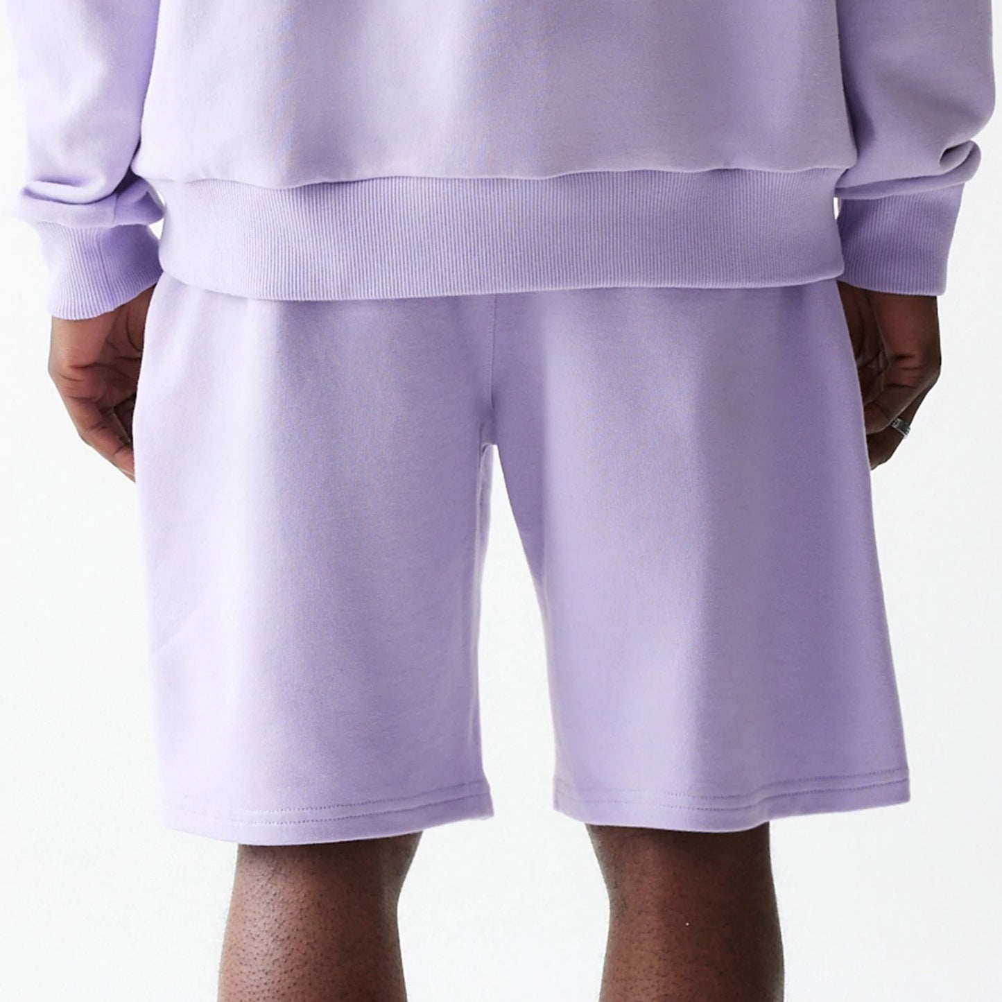 The Male model is wearing New Era Pastel Purple Oversized One Panel Shorts 6