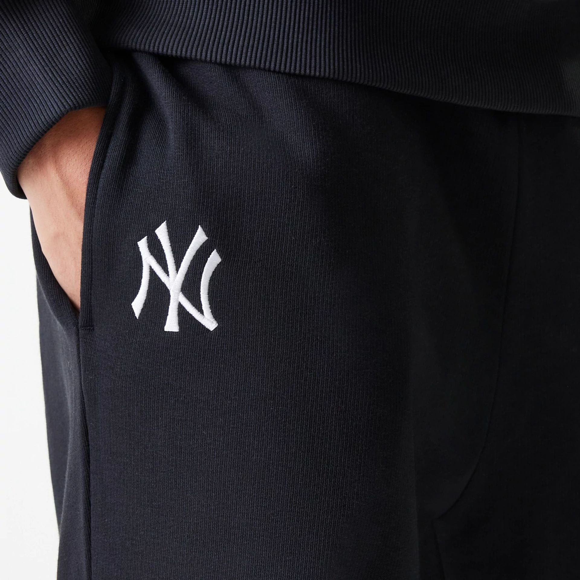 The Male model is wearing New York Yankees MLB League Essential Midi Black Joggers 4