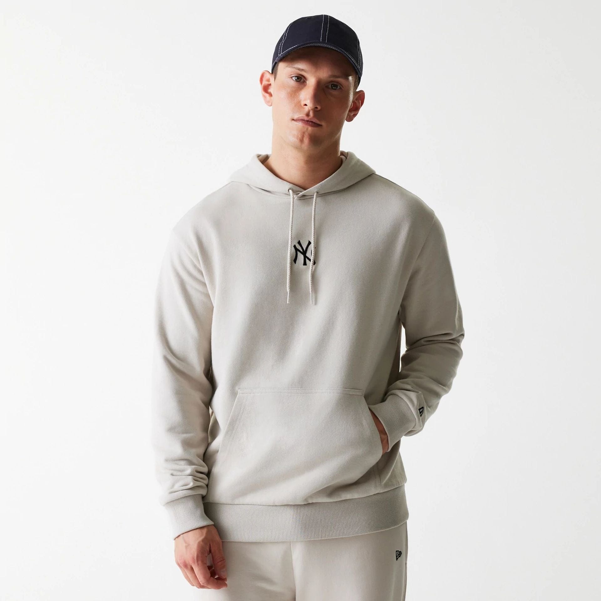 The Male model is wearing New York Yankees MLB League Essential Midi Cream Oversized Pullover Hoodie 1