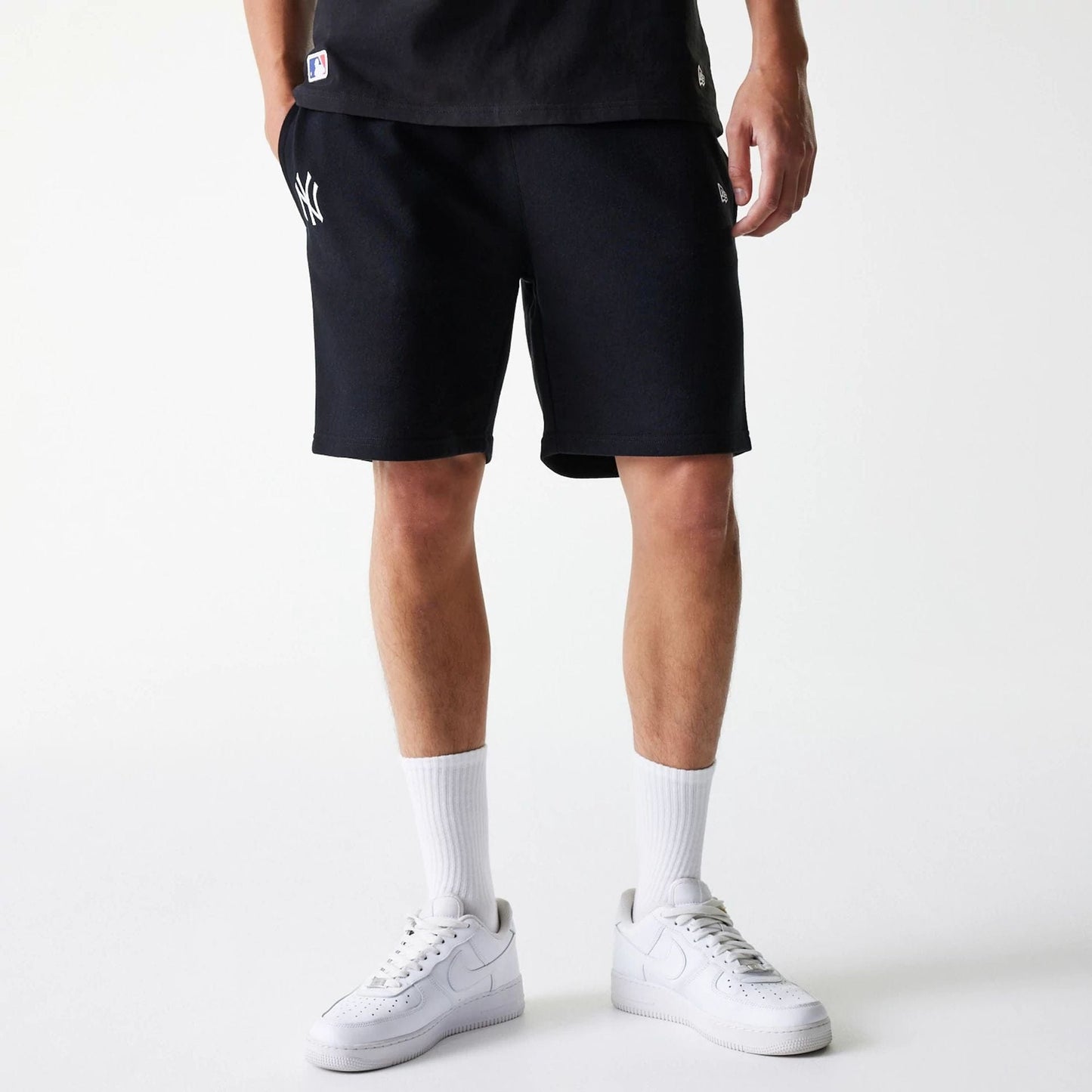 The Male model is wearing New York Yankees MLB League Essential Black Shorts 1