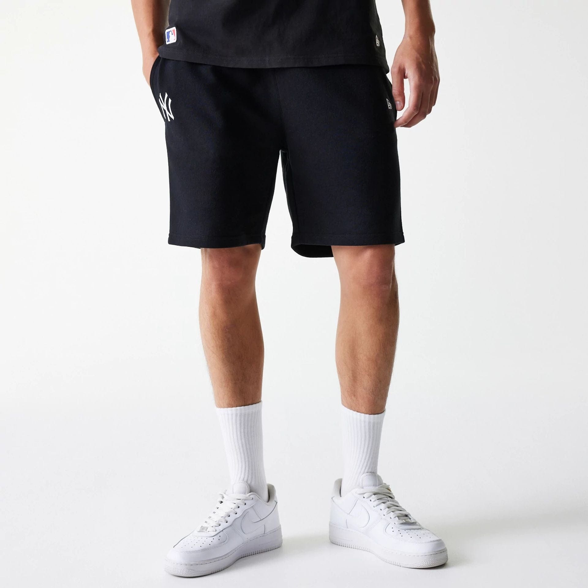 The Male model is wearing New York Yankees MLB League Essential Black Shorts 1