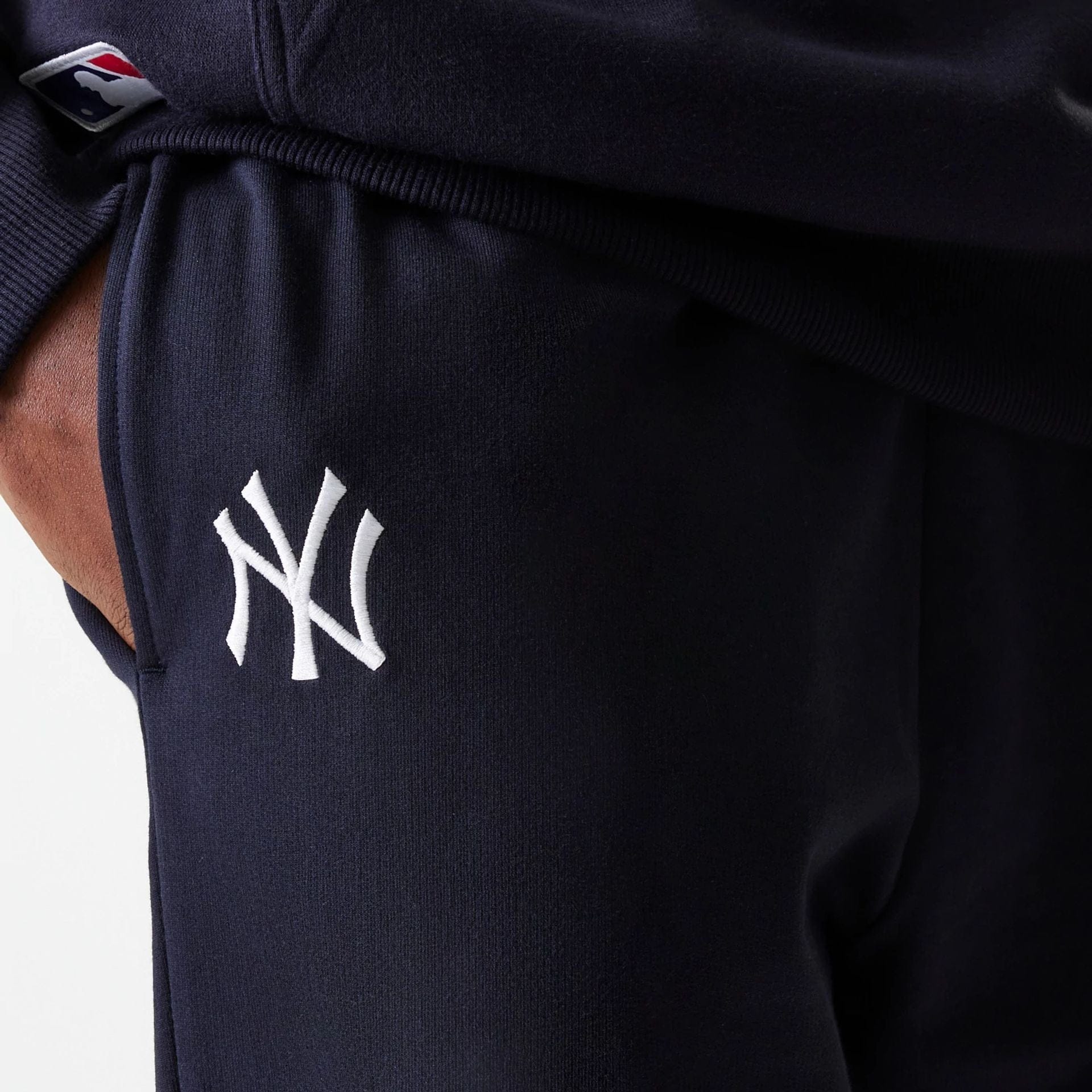 The Male model is wearing New York Yankees MLB League Essential Midi Navy Joggers 4