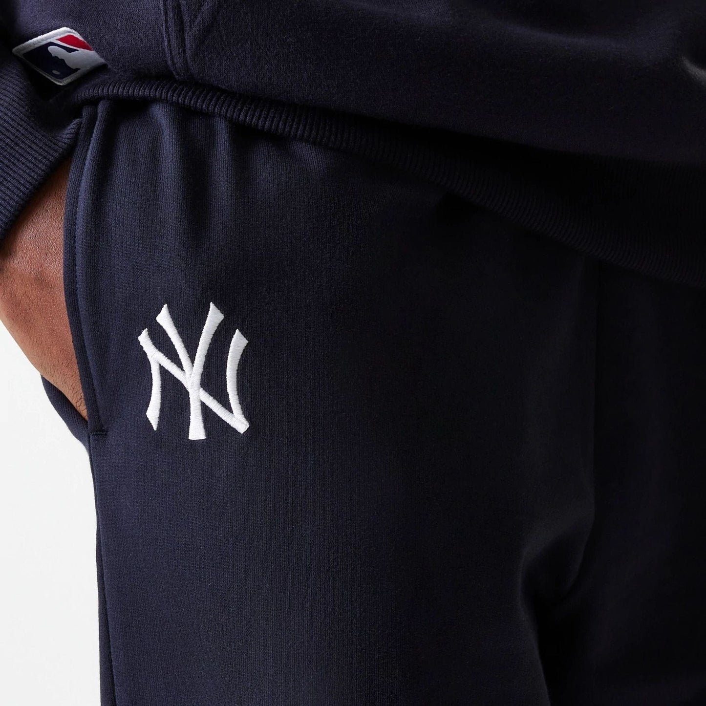 The Male model is wearing New York Yankees MLB League Essential Midi Navy Joggers 4