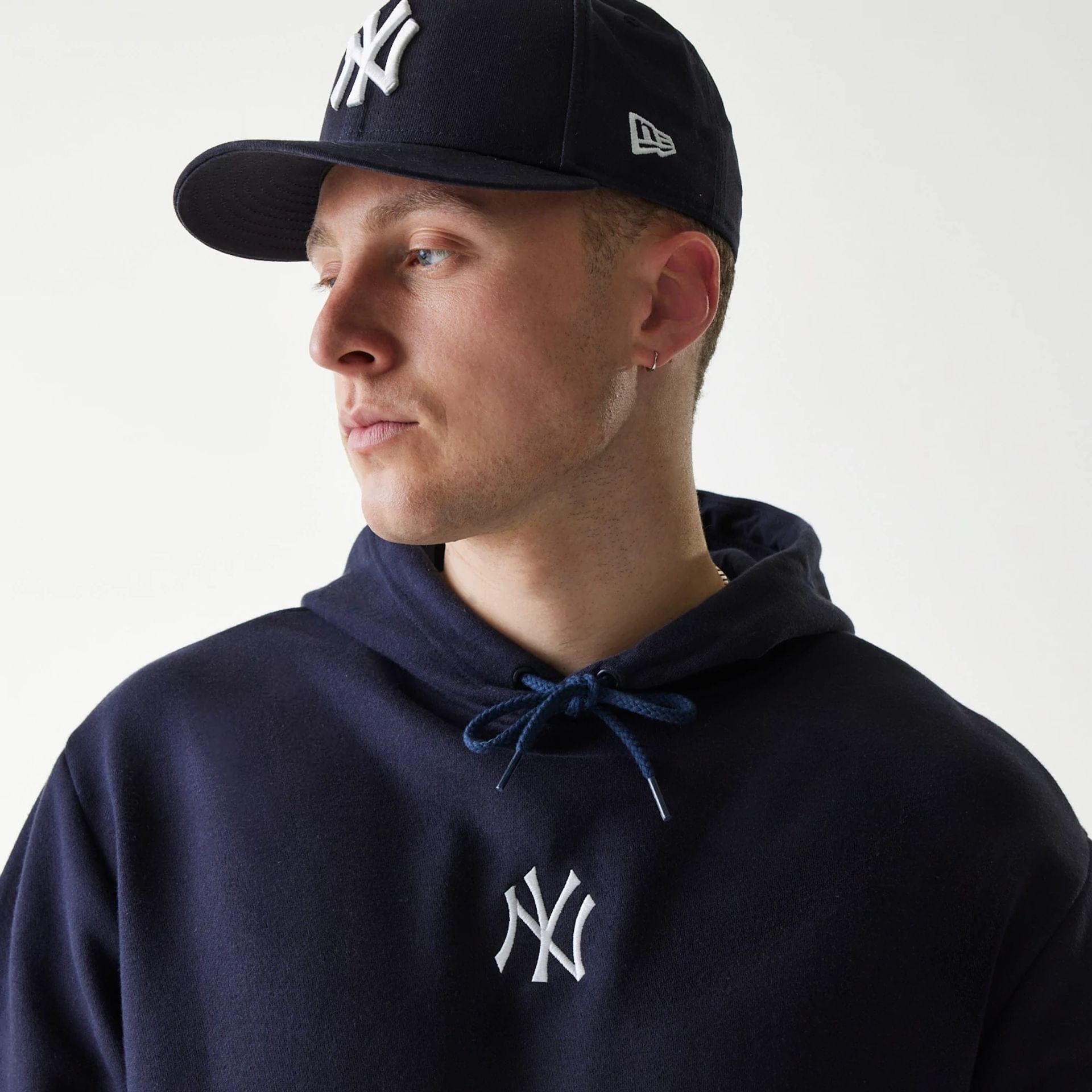 The Male model is wearing New York Yankees MLB League Essential Navy Oversized Pullover Hoodie 4