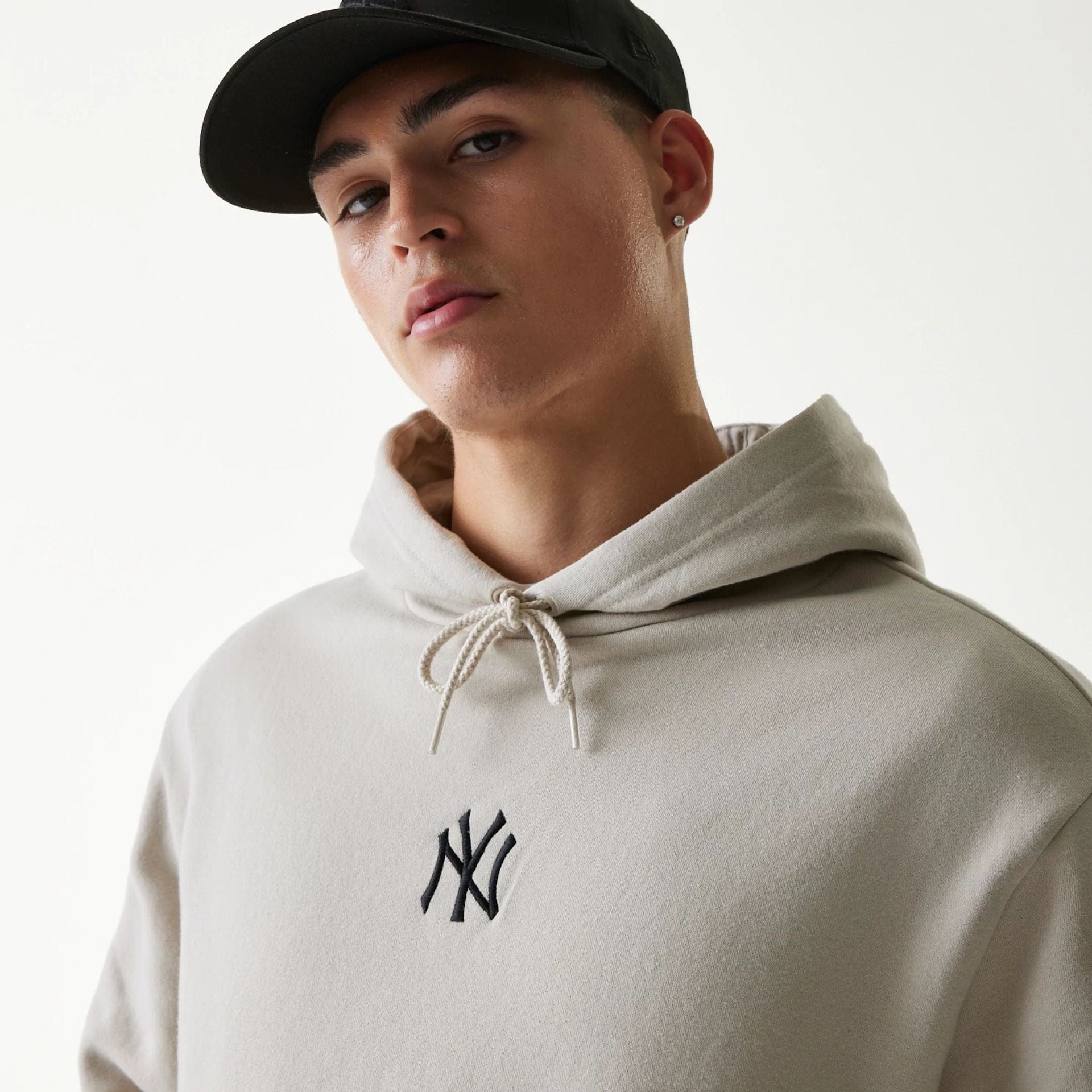 The Male model is wearing New York Yankees MLB League Essential Cream Oversized Pullover Hoodie 6
