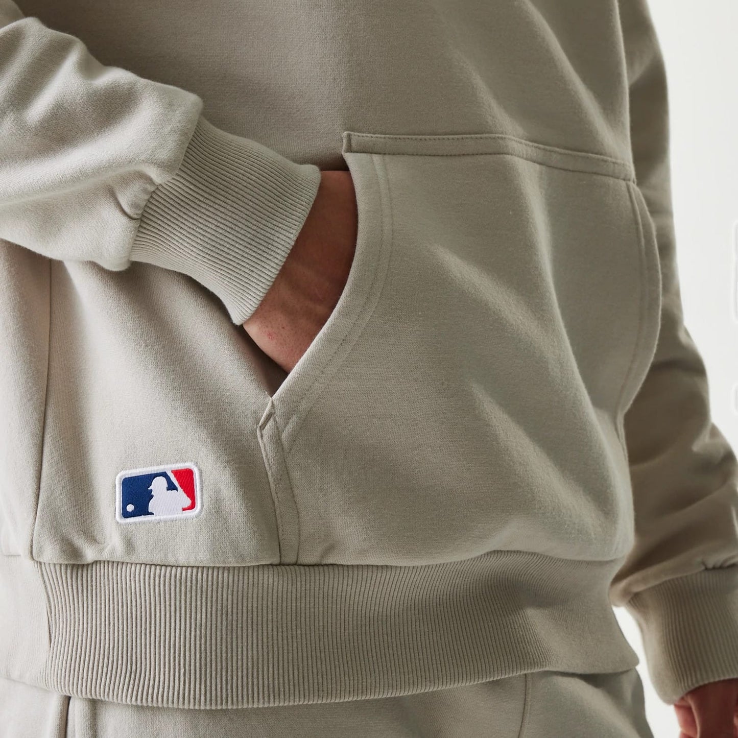 The Male model is wearing New York Yankees MLB League Essential Cream Oversized Pullover Hoodie 4