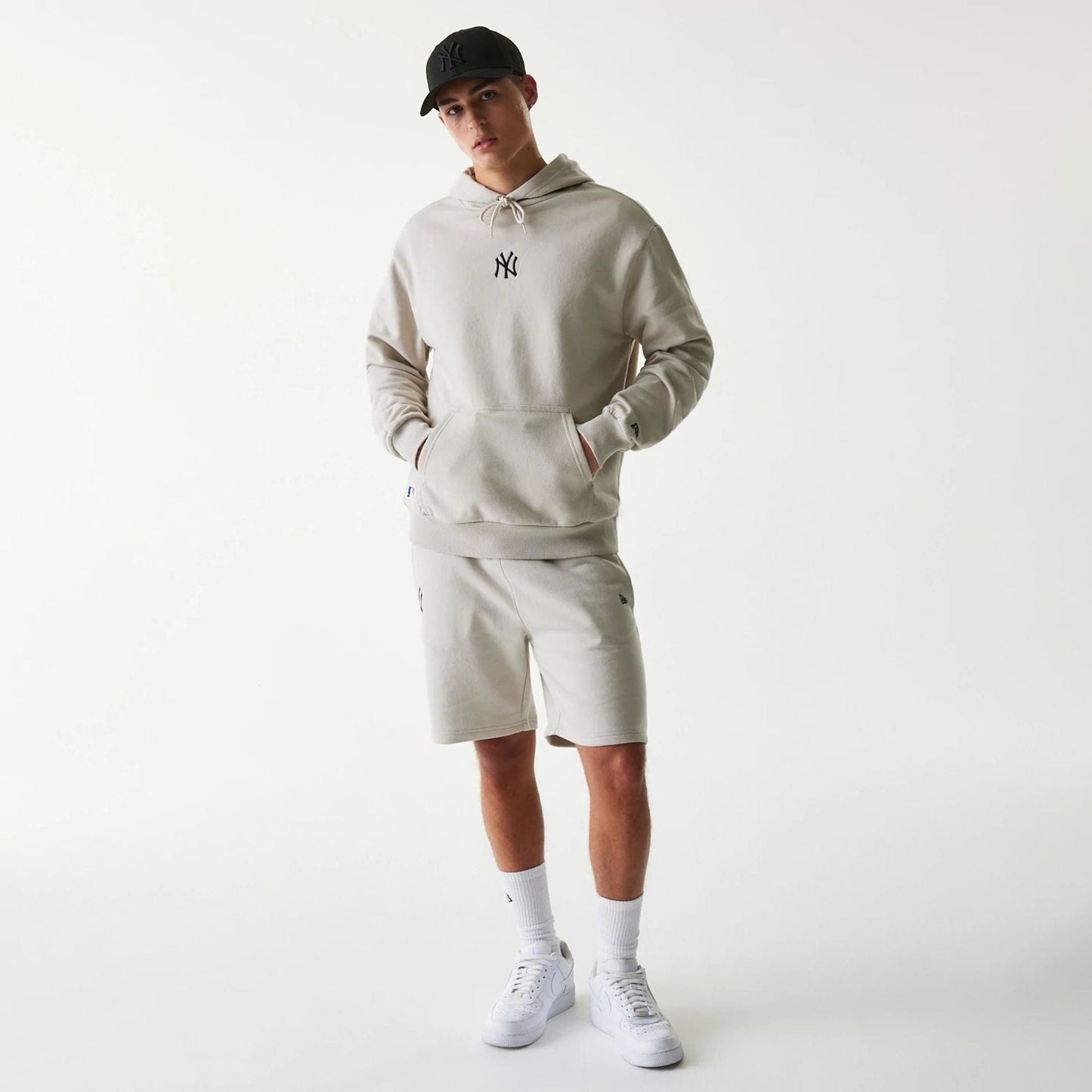 The Male model is wearing New York Yankees MLB League Essential Cream Oversized Pullover Hoodie 8