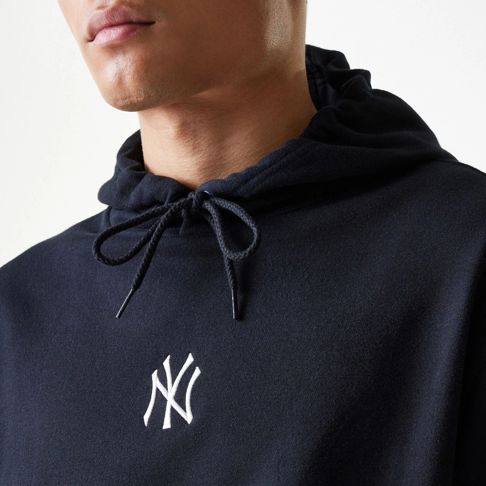 The Male model is wearing New York Yankees MLB League Essential Black Oversized Pullover Hoodie 4