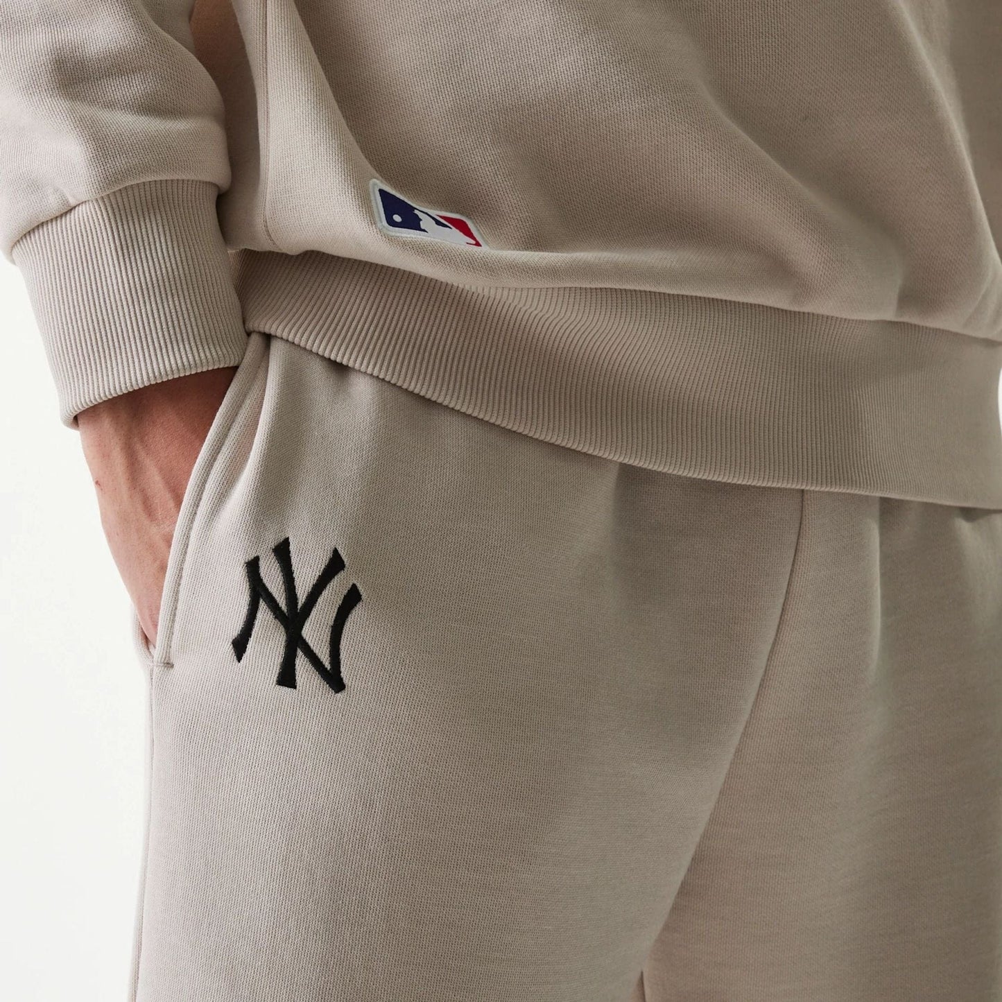 The Male model is wearing New York Yankees MLB League Essential Cream Joggers 6