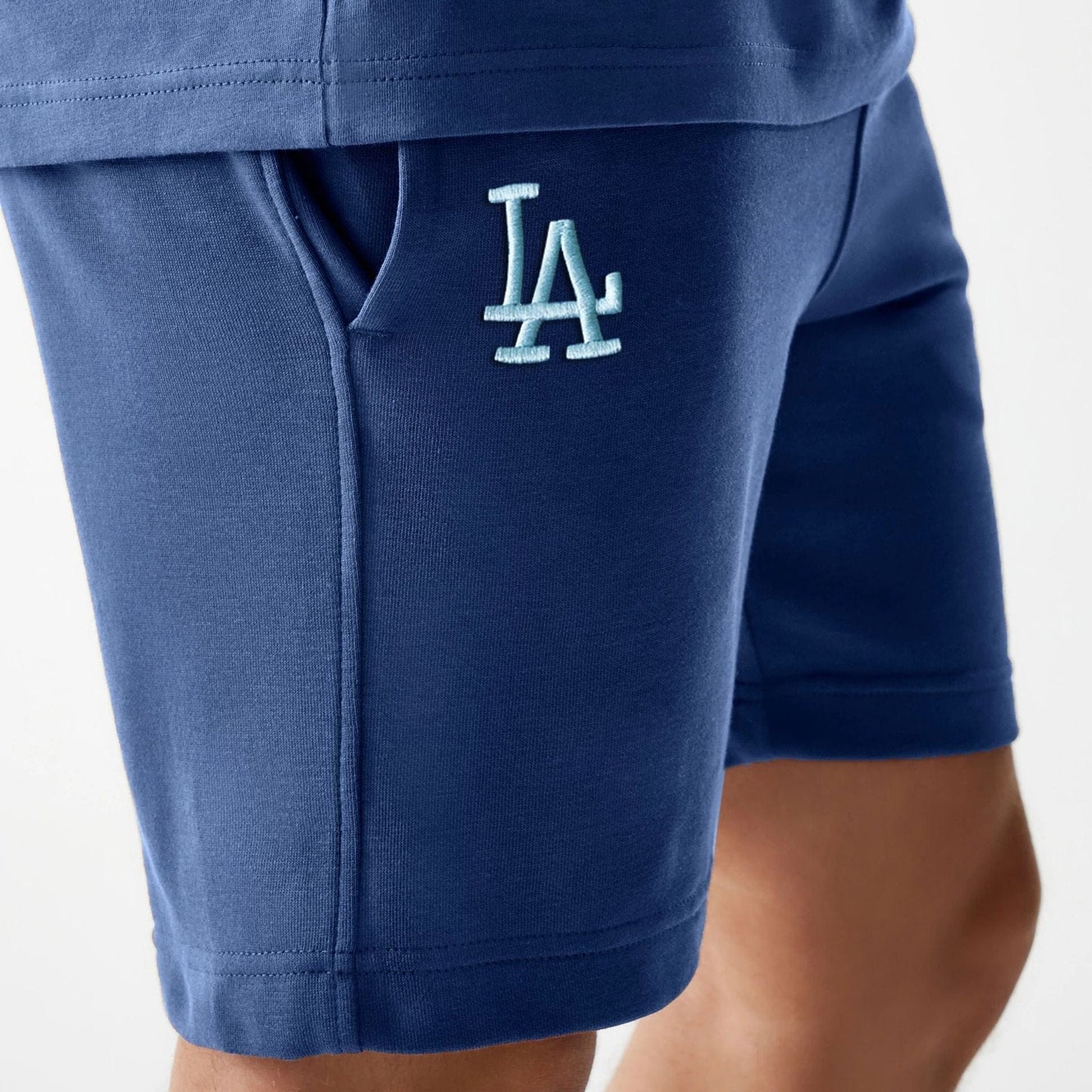 The Male model is wearing LA Dodgers MLB Midi League Essential Dark Blue Shorts 3
