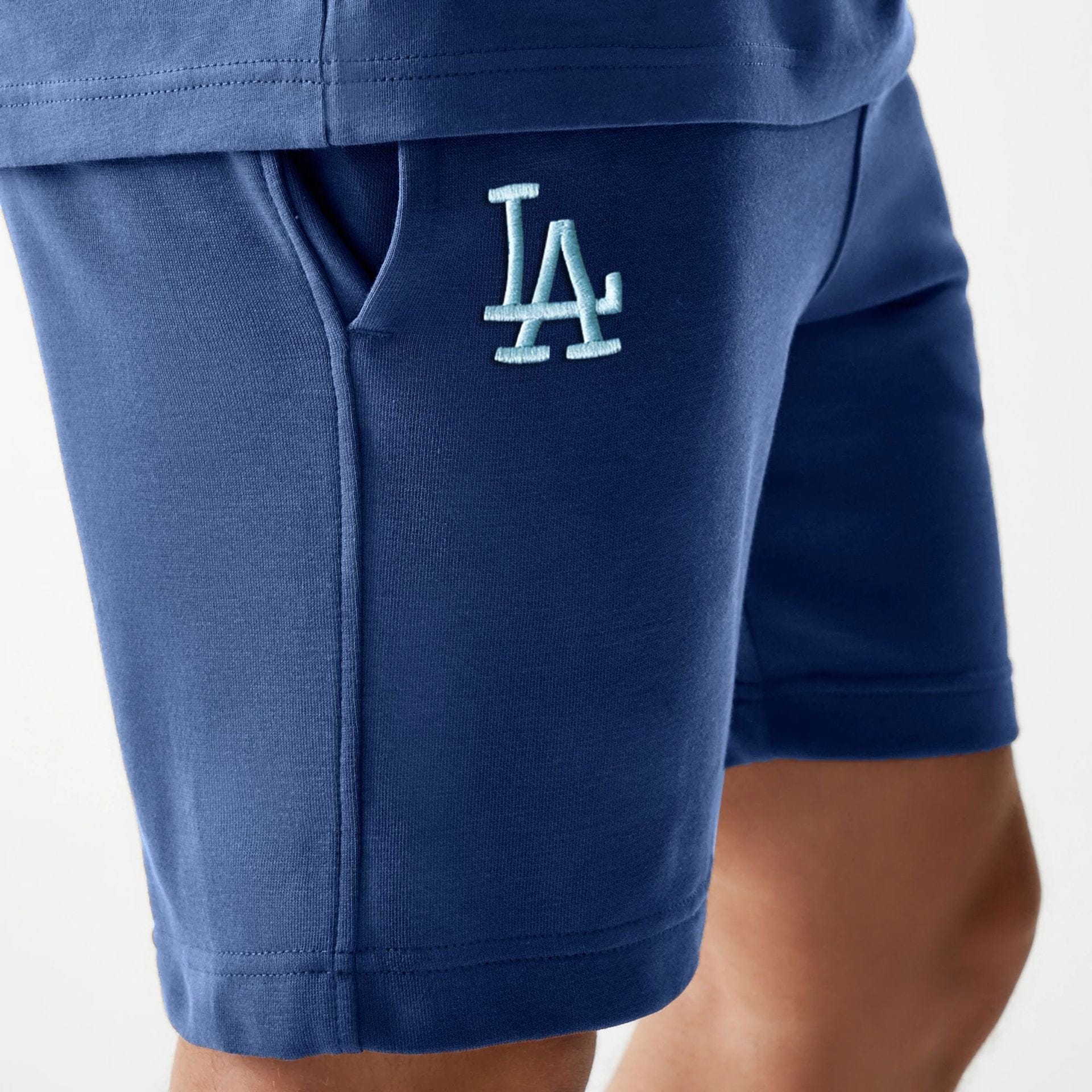 The Male model is wearing LA Dodgers MLB Midi League Essential Dark Blue Shorts 3