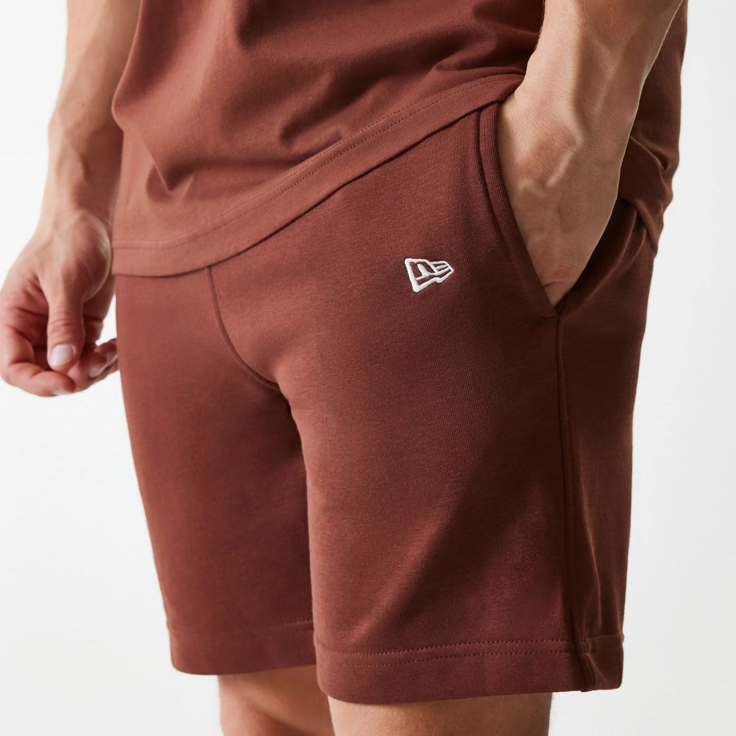 The Male model is wearing New York Yankees MLB Midi League Essential Brown Shorts 4