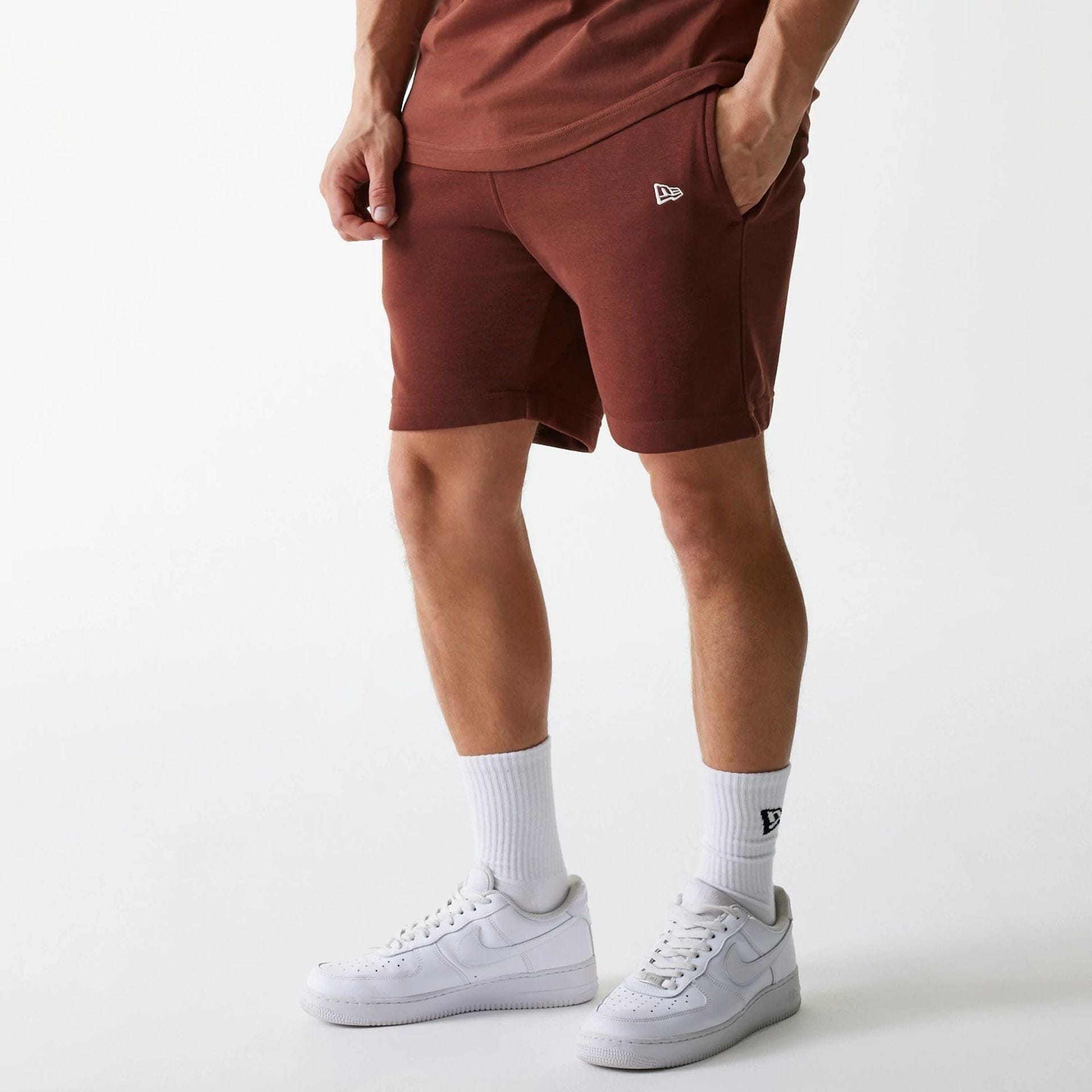 The Male model is wearing New York Yankees MLB Midi League Essential Brown Shorts 1