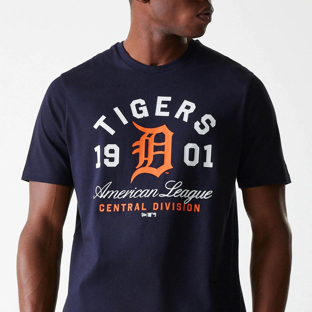 New Era Detroit Tigers MLB Wordmark Navy T-Shirt, on-model view showing bold white lettering and orange logo at centre on the chest, with 'Tigers', '1901', 'American League' and 'Central Division' text displayed around the design.