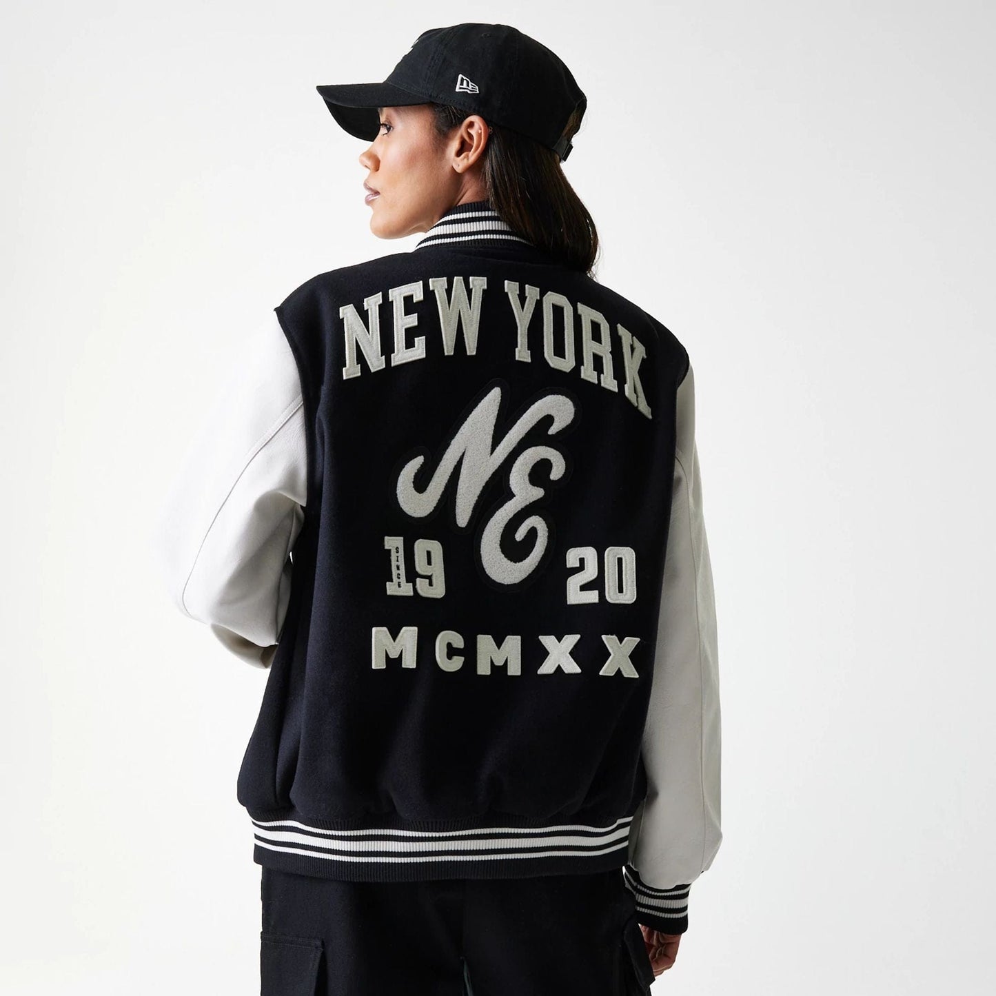 The Male model is wearing New Era Patch Black Varsity Jacket 2