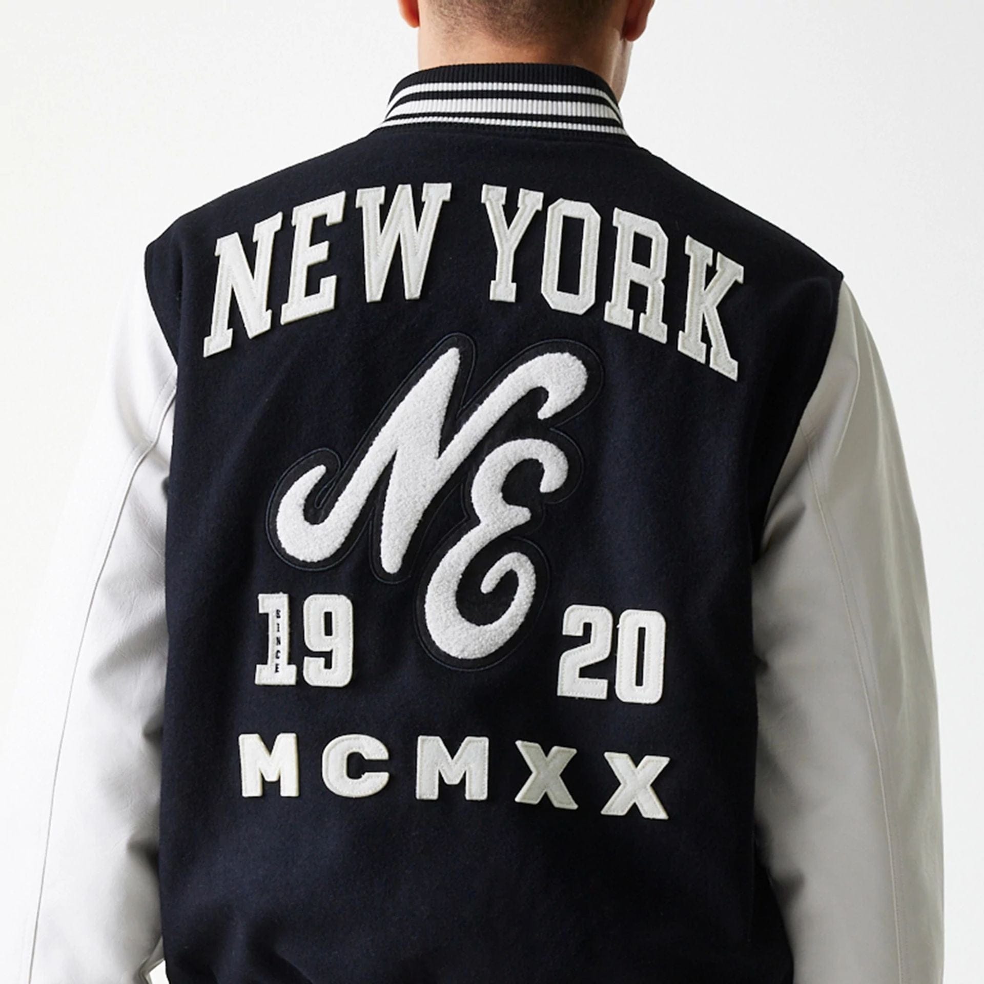 The Male model is wearing New Era Patch Black Varsity Jacket 7