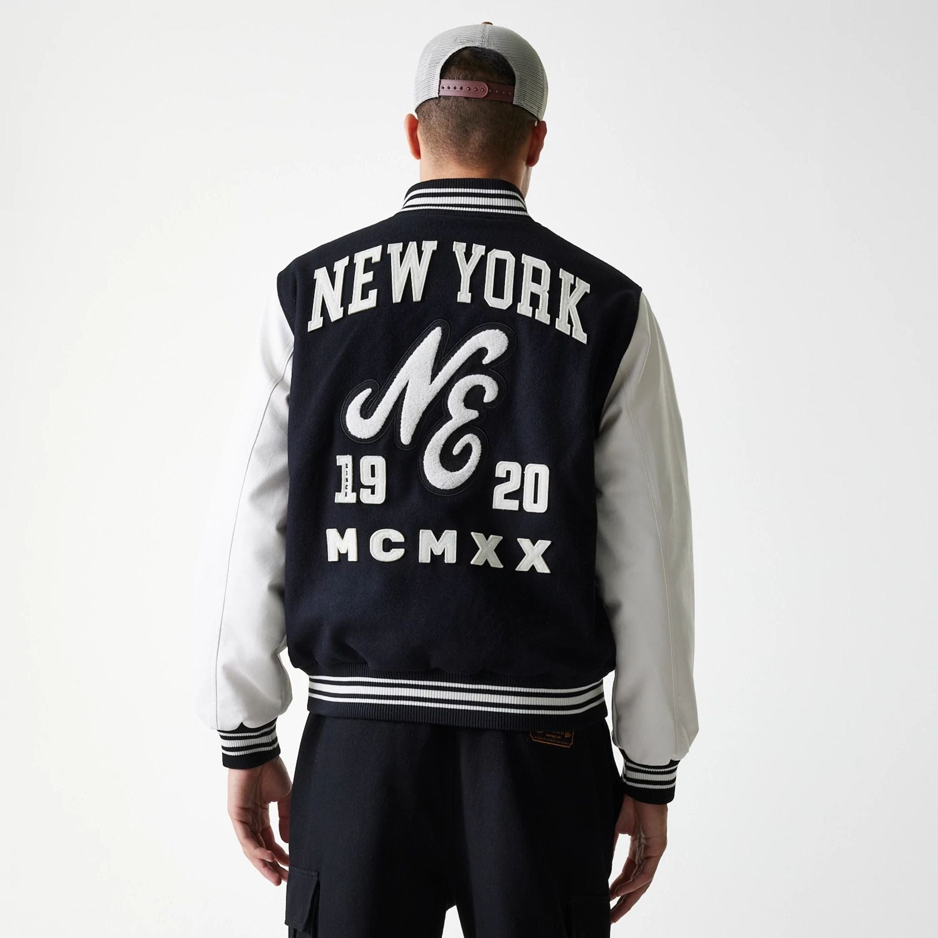 The Male model is wearing New Era Patch Black Varsity Jacket 8