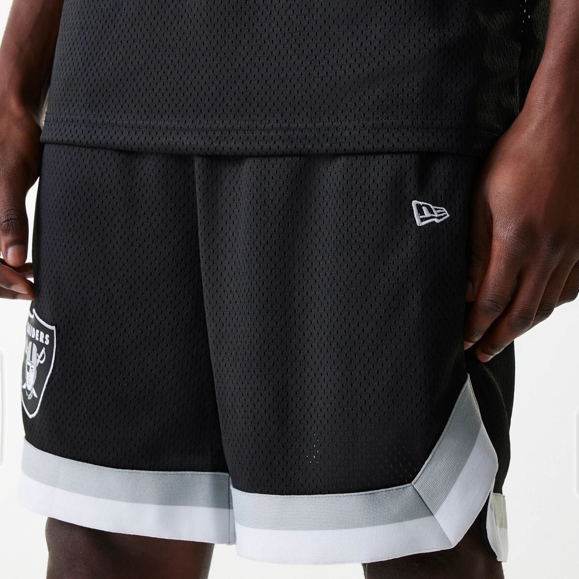 The Male model is wearing Las Vegas Raiders NFL Mesh Black Shorts 4