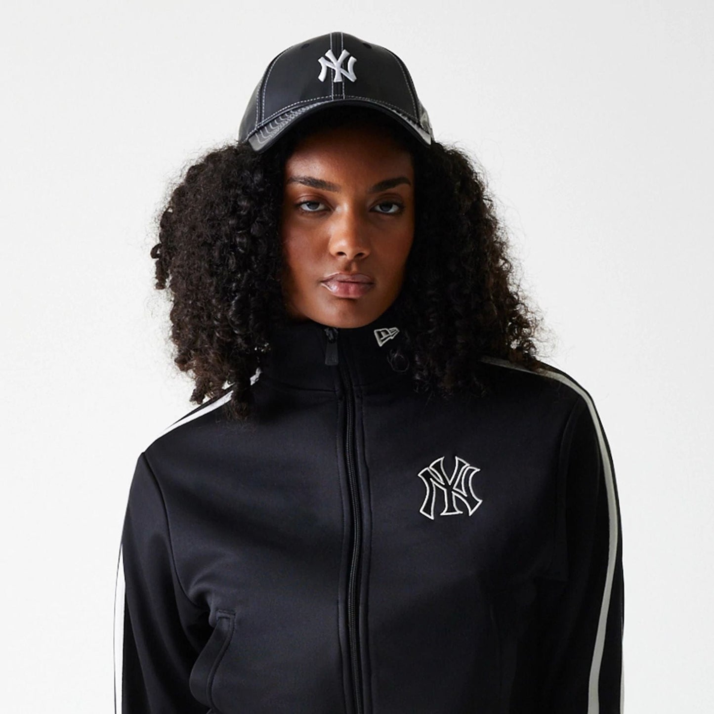 The Female model is wearing New York Yankees Womens MLB Midi Logo Black Track Jacket 5