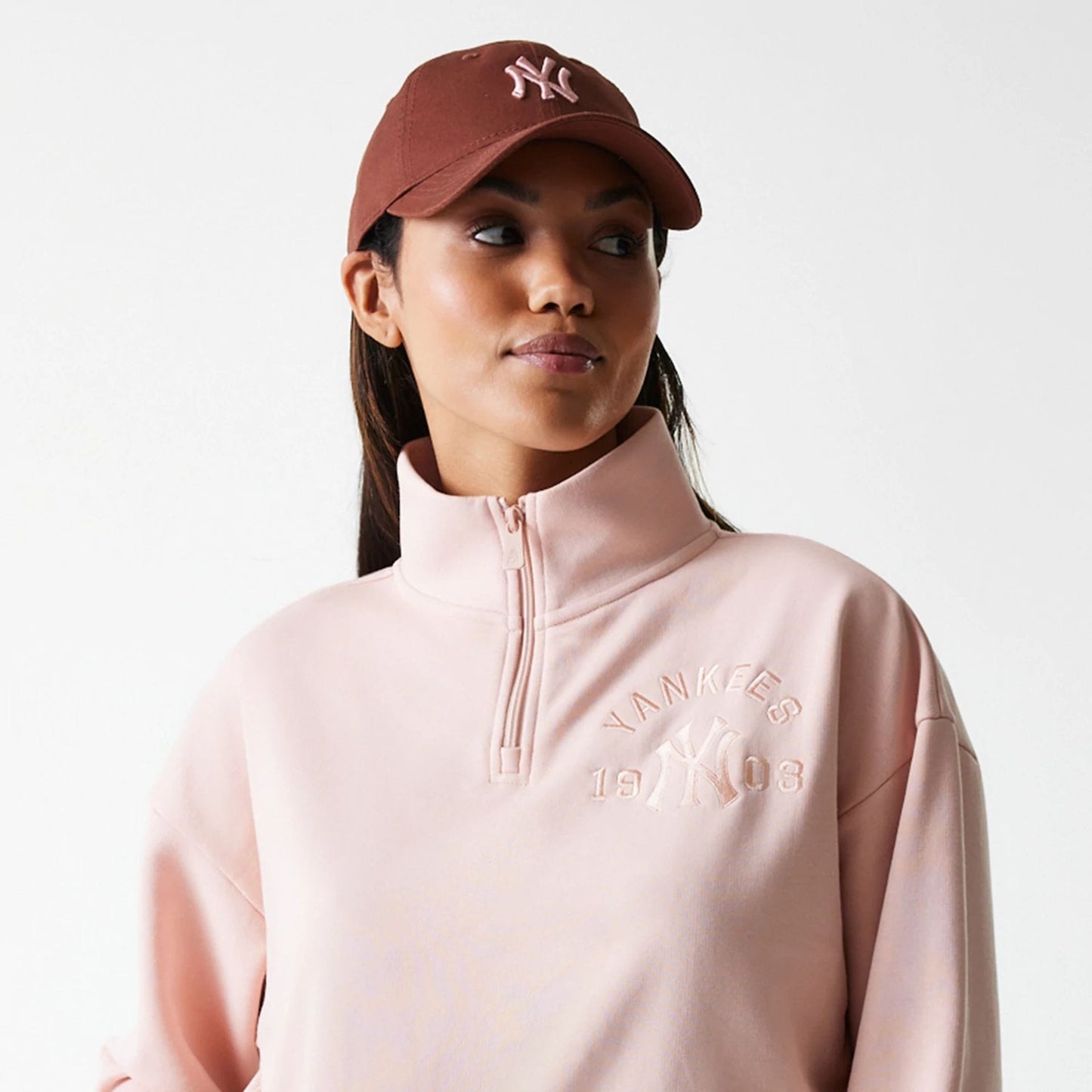 The Female model is wearing New York Yankees Womens MLB Tonal Pastel Pink Cropped 1/4 Zip Sweater 6