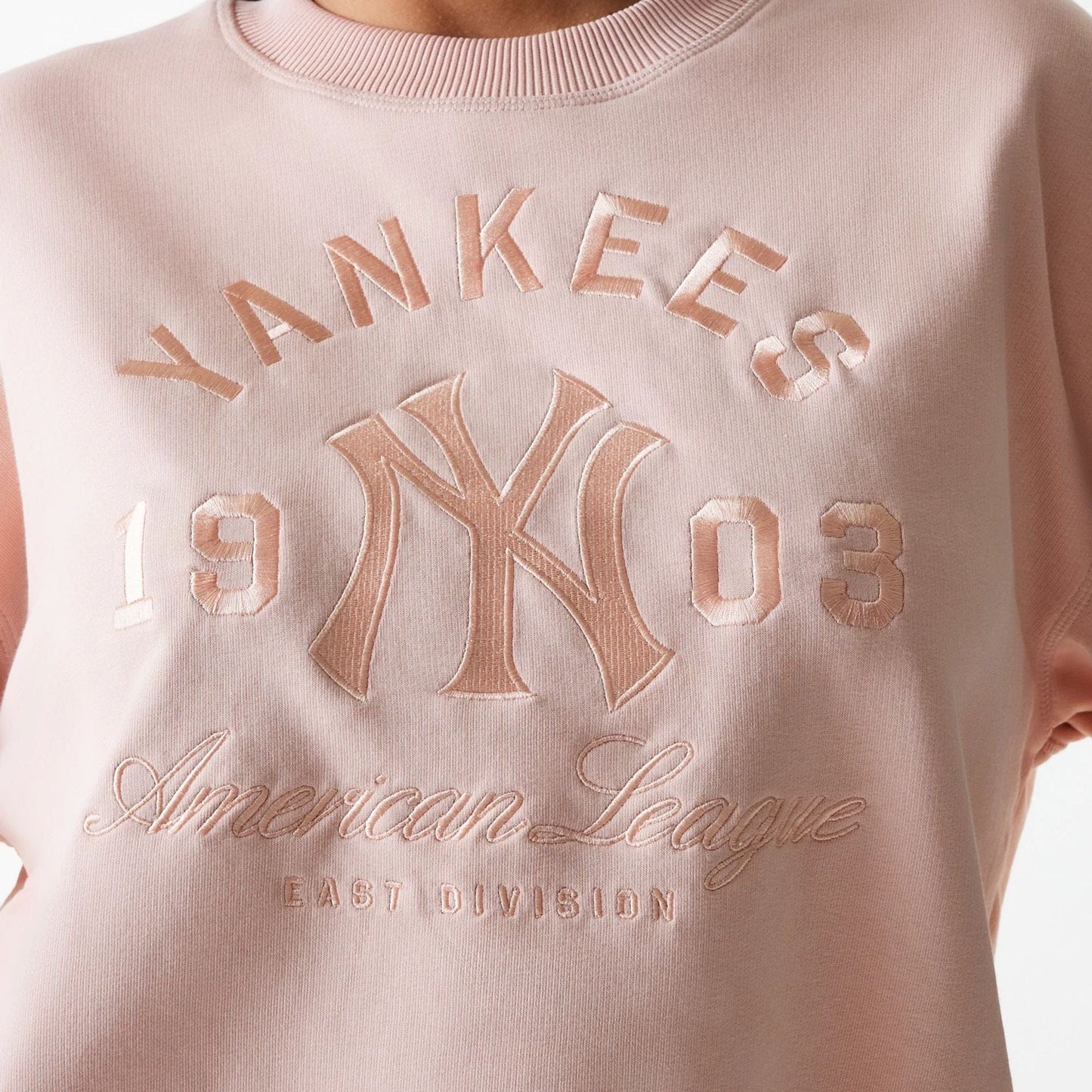 The Female model is wearing New York Yankees Womens MLB Tonal Graphic Pastel Pink Oversized Crew Neck Sweater 4
