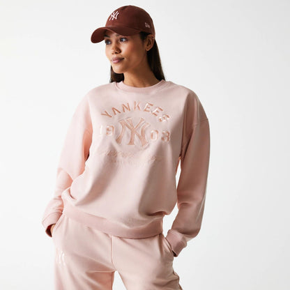 The Female model is wearing New York Yankees Womens MLB Tonal Graphic Pastel Pink Oversized Crew Neck Sweater 1