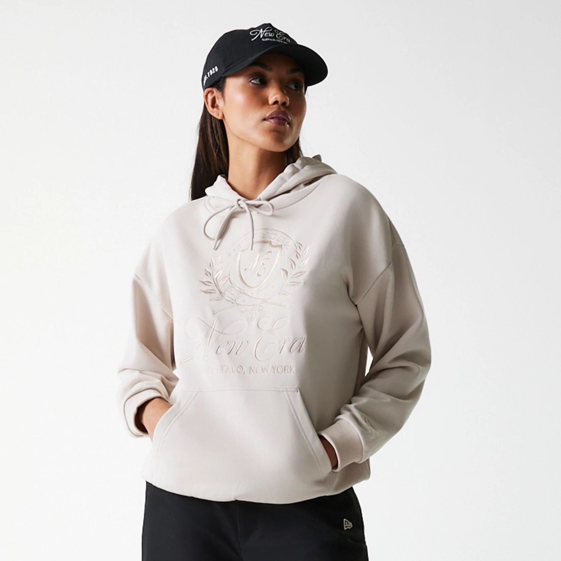 The Female model is wearing Womens New Era Crest Light Beige Pullover Hoodie 3