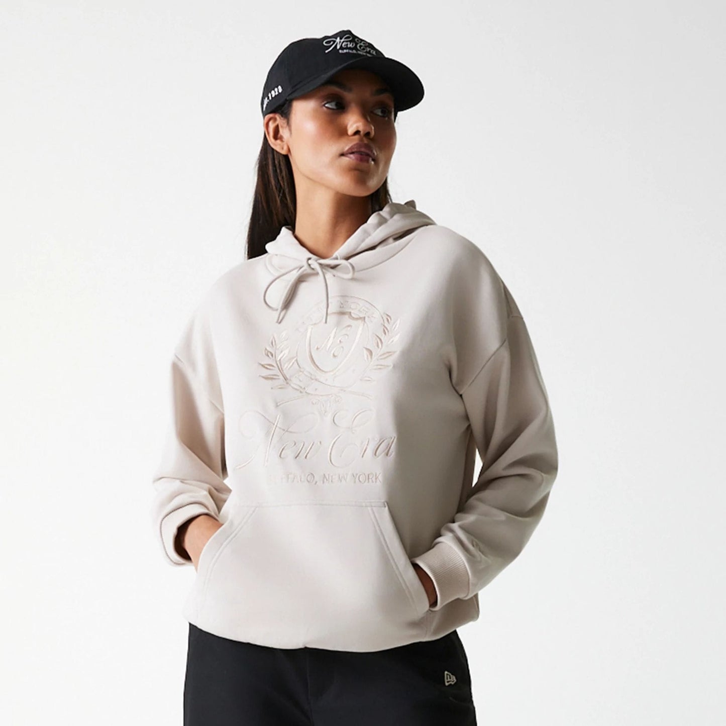 The Female model is wearing Womens New Era Crest Light Beige Pullover Hoodie 3