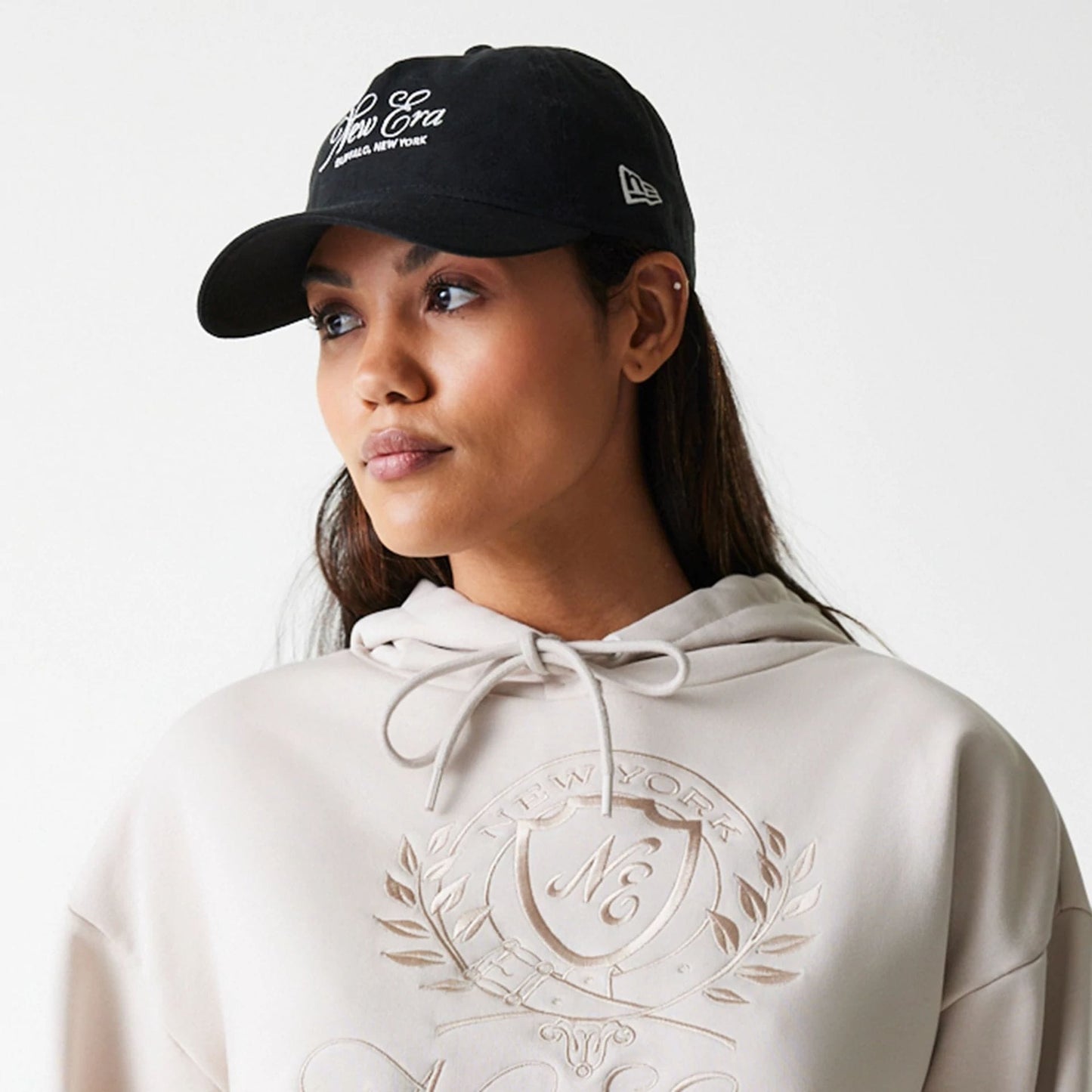 The Female model is wearing Womens New Era Crest Light Beige Pullover Hoodie 5