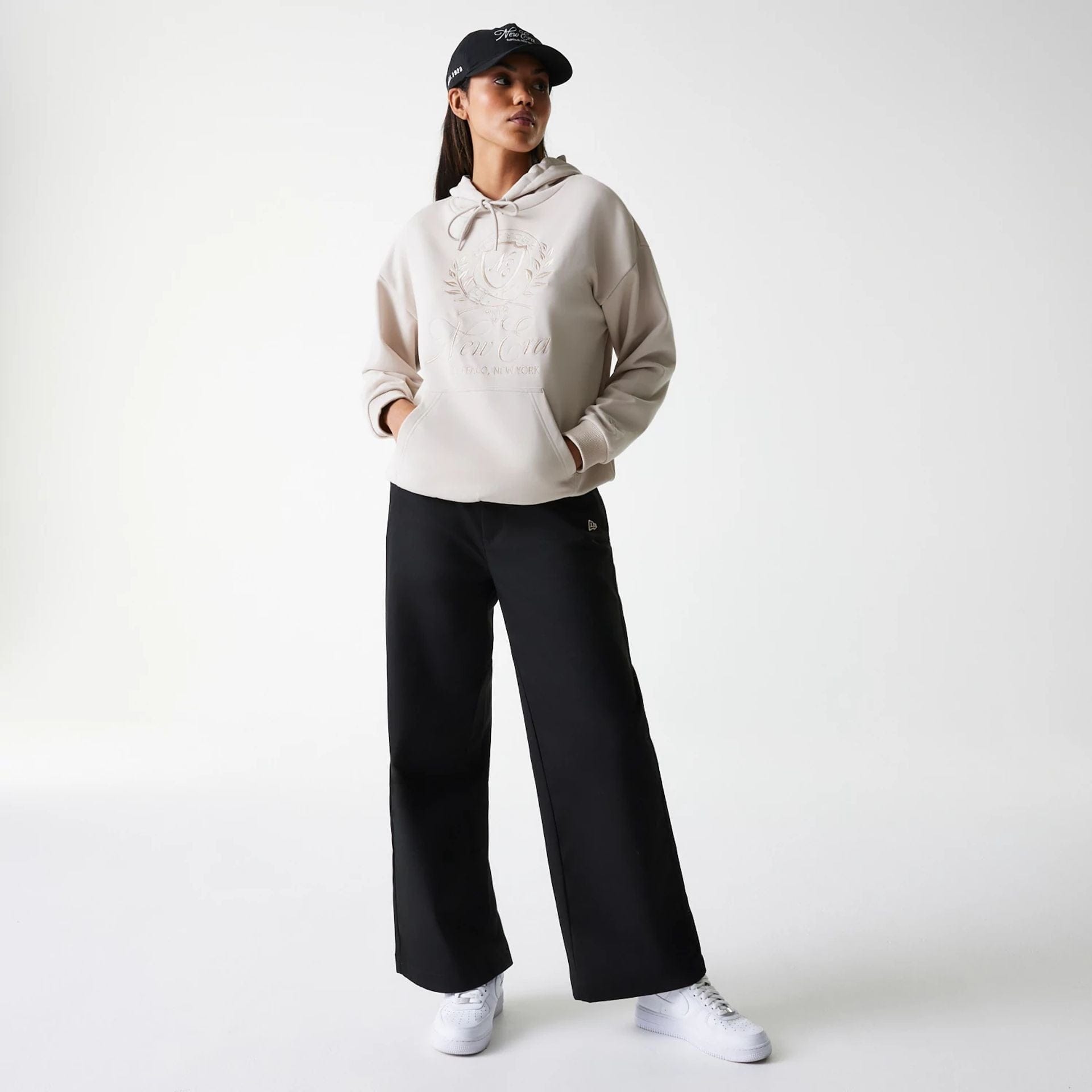 The Female model is wearing Womens New Era Crest Light Beige Pullover Hoodie 8